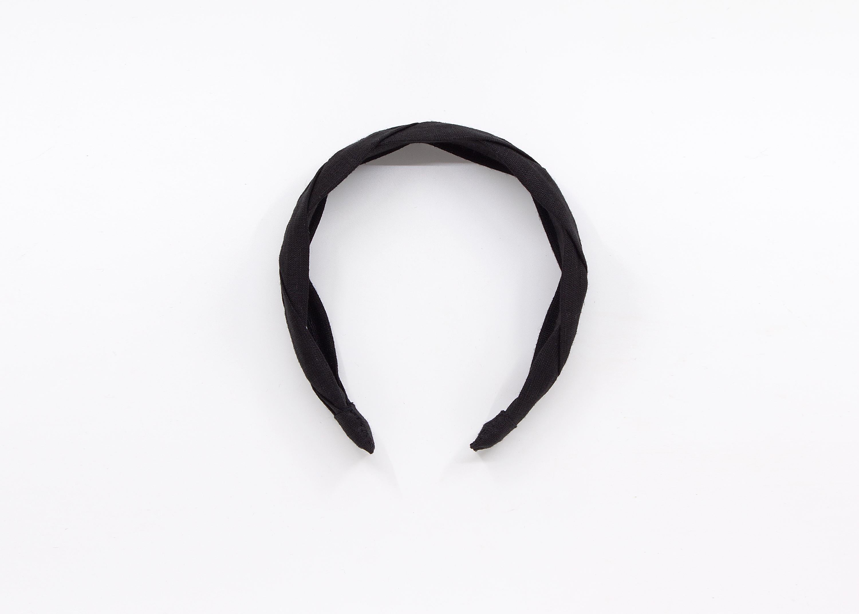 May include: A black braided headband made of fabric.
