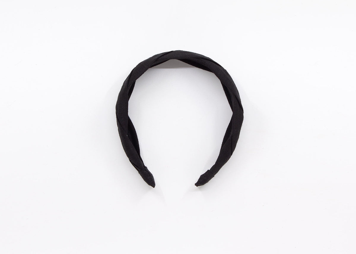 May include: A black braided headband made of fabric.