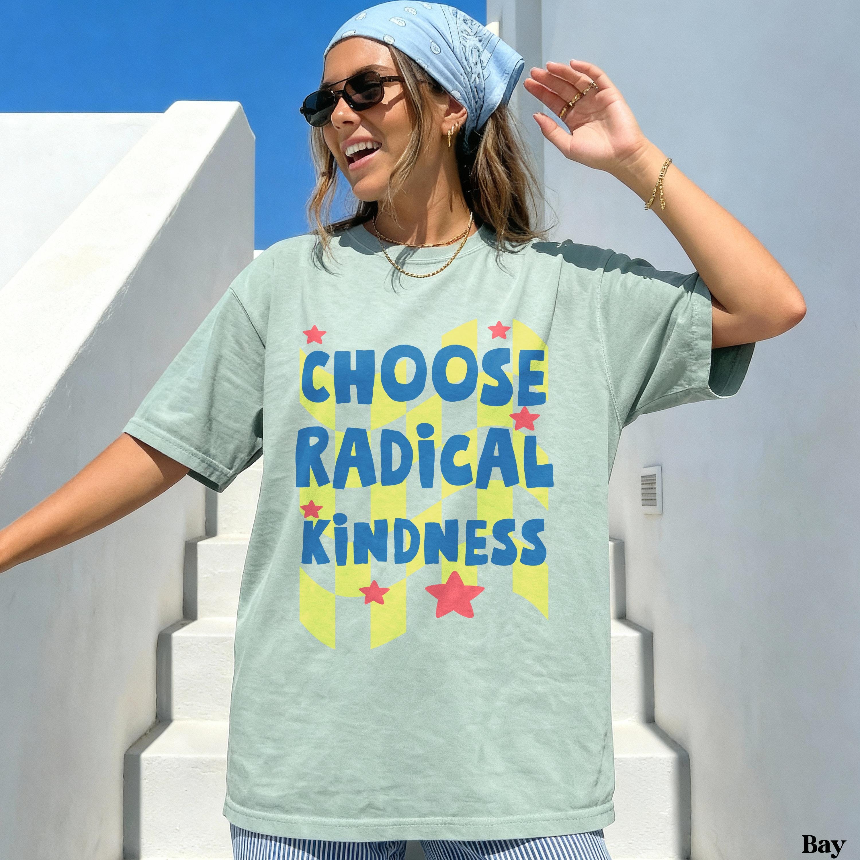 Woman in light green t-shirt with "CHOOSE RADICAL KINDNESS" text and checkered pattern.