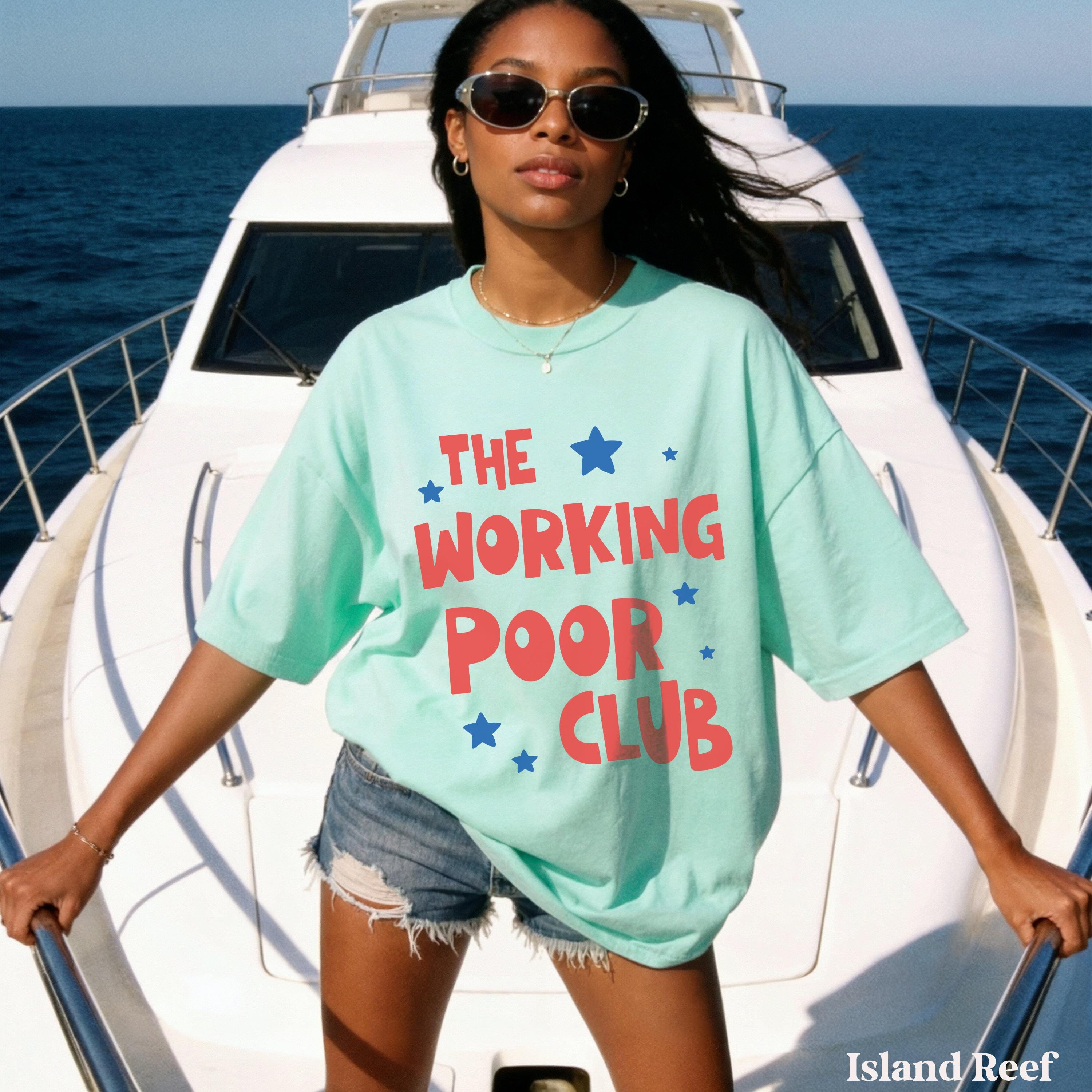 Woman in turquoise t-shirt with "The Working Poor Club" text on a boat.