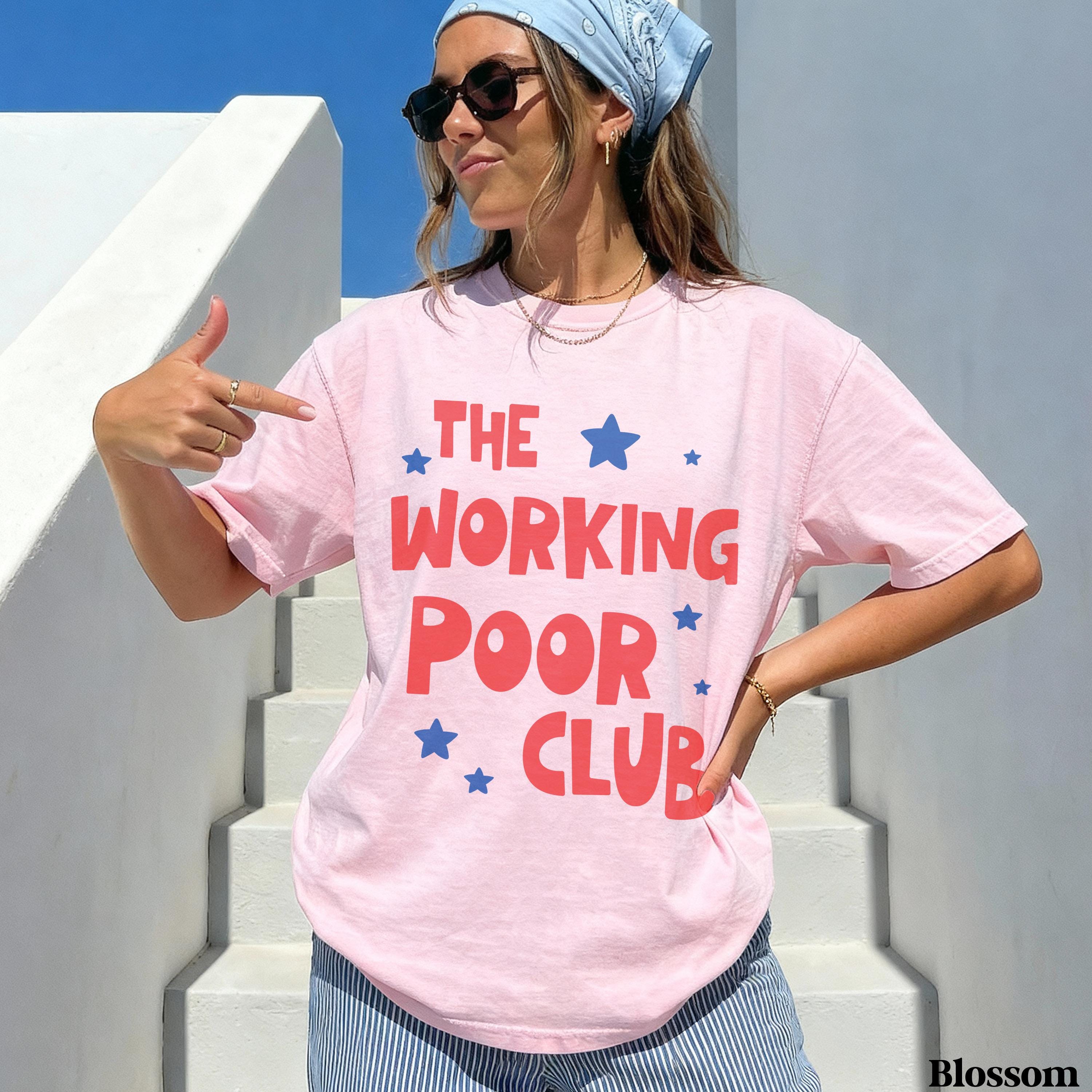 Woman wearing a pink t-shirt with red text and blue stars, "THE WORKING POOR CLUB".