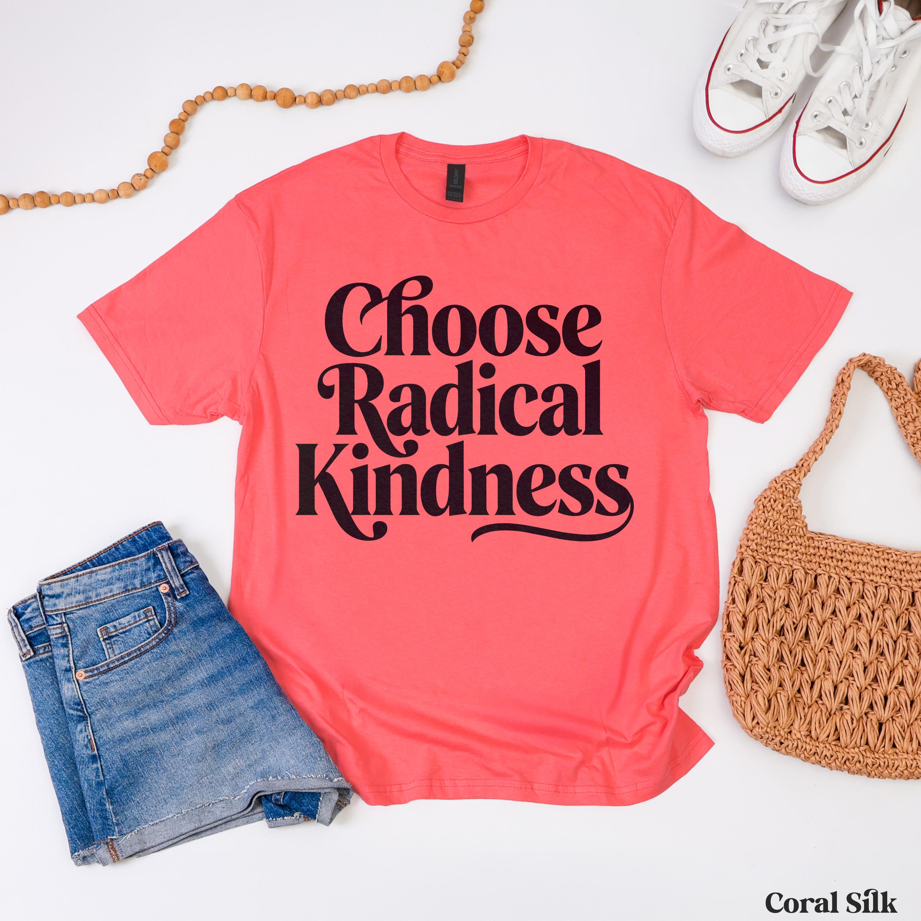 Coral silk t-shirt with "Choose Radical Kindness" text, styled with jeans and a straw bag.