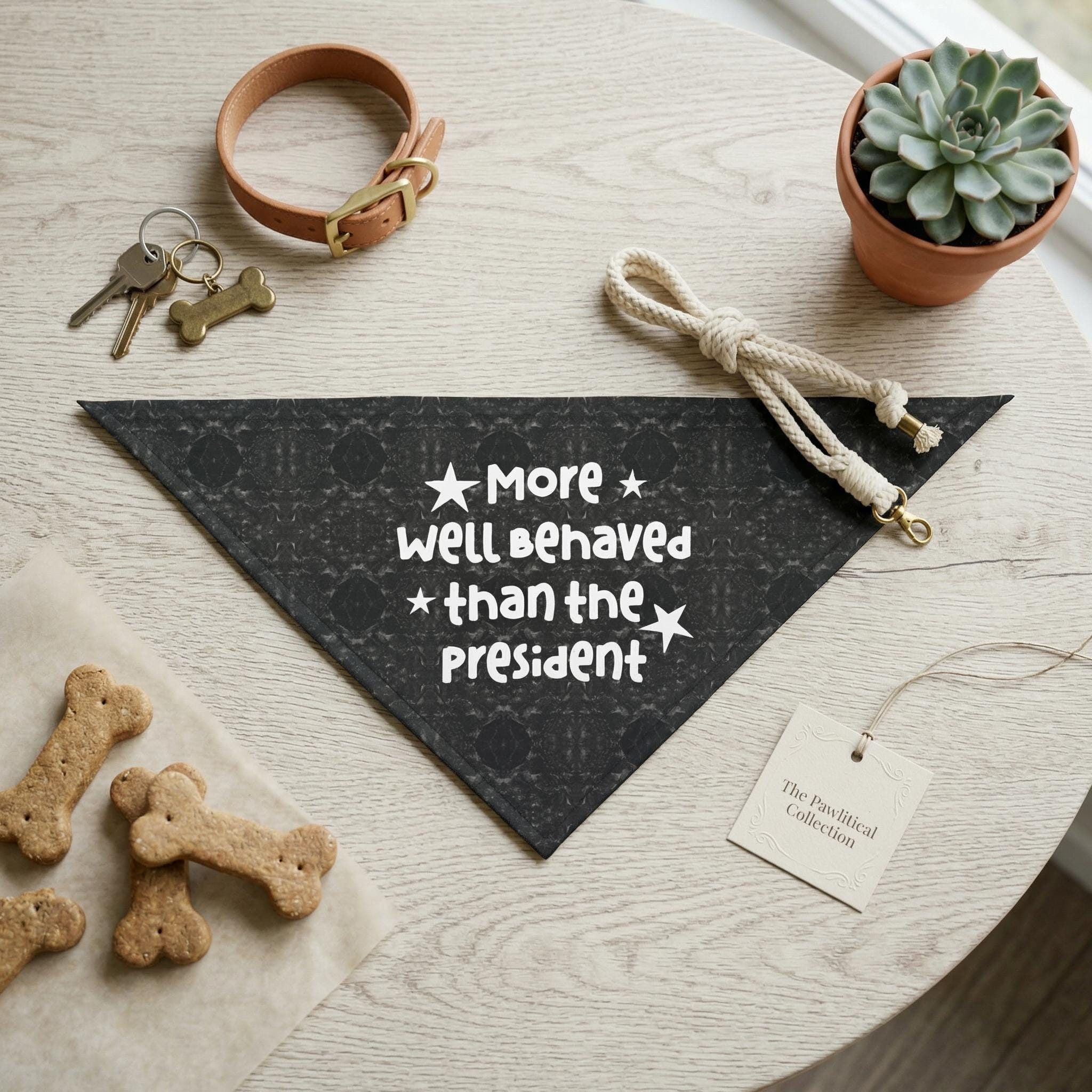 Black patterned dog bandana with text "More * well behaved * than the President".