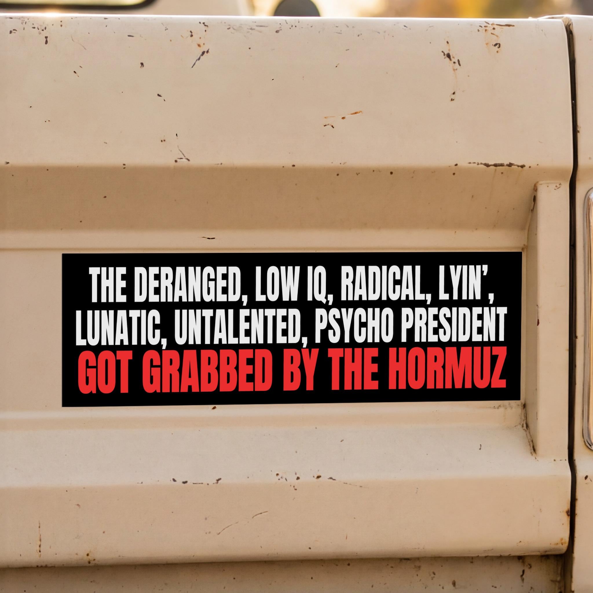Black bumper sticker with white and red text about a "psycho president" and the Hormuz.