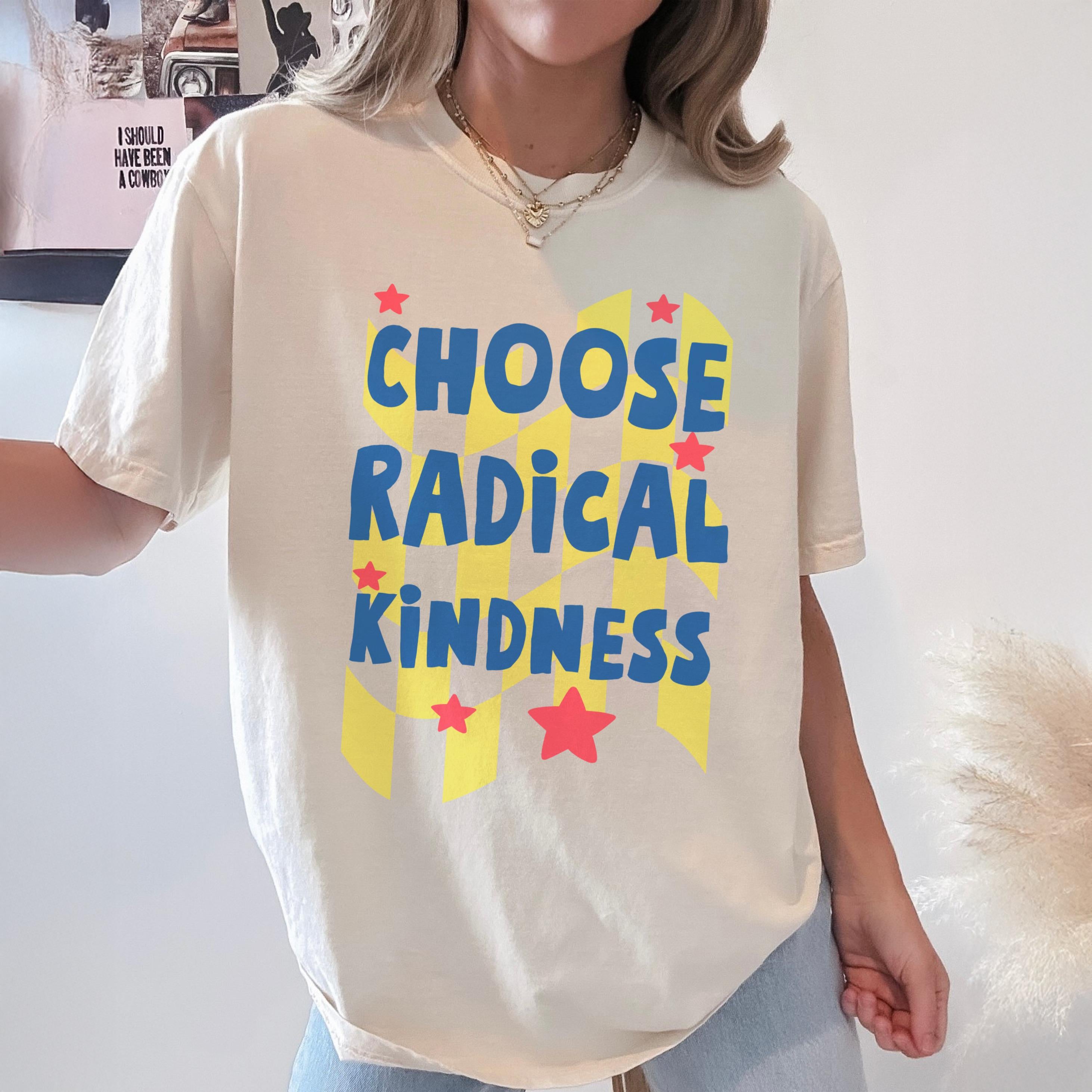 Cream t-shirt with "CHOOSE RADICAL KINDNESS" in blue and yellow, with red stars.