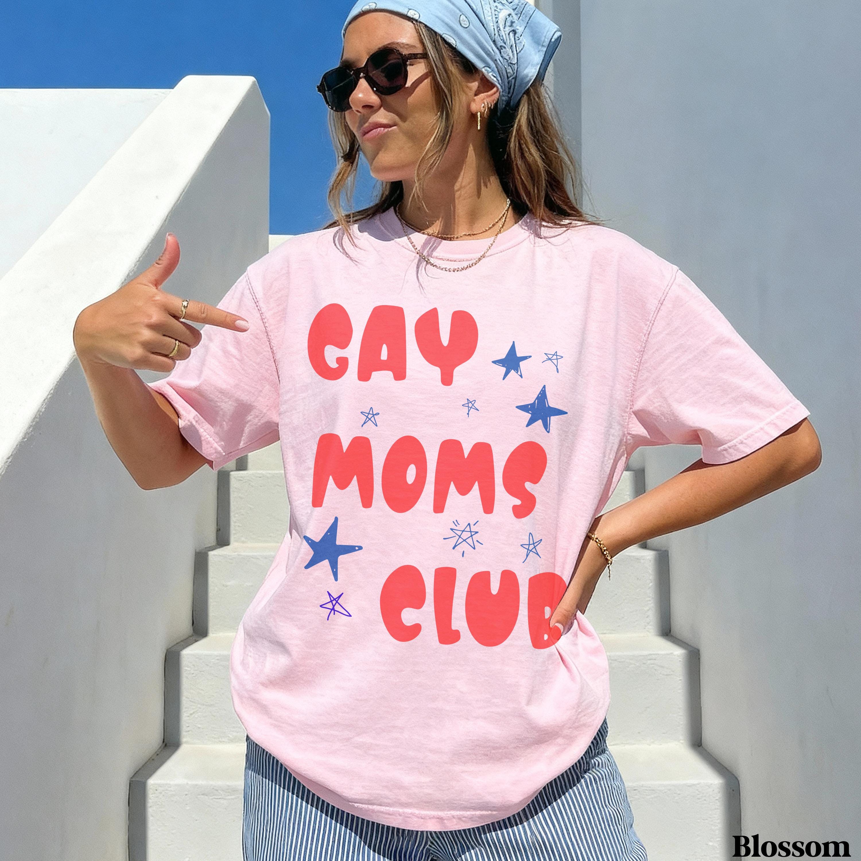 Pink t-shirt with "GAY MOMS CLUB" in red and blue text.