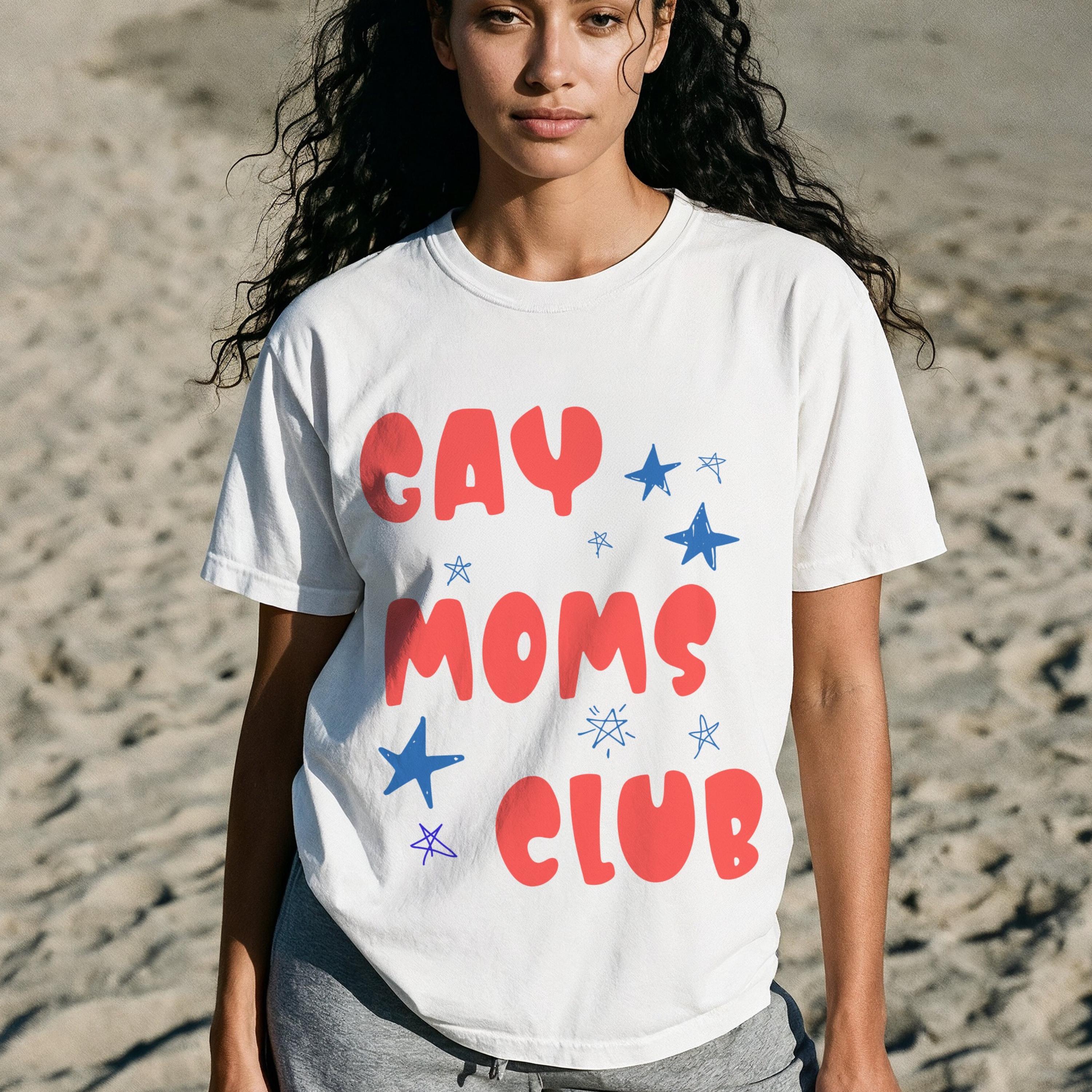 White t-shirt with "GAY MOMS CLUB" in red and blue text and stars.