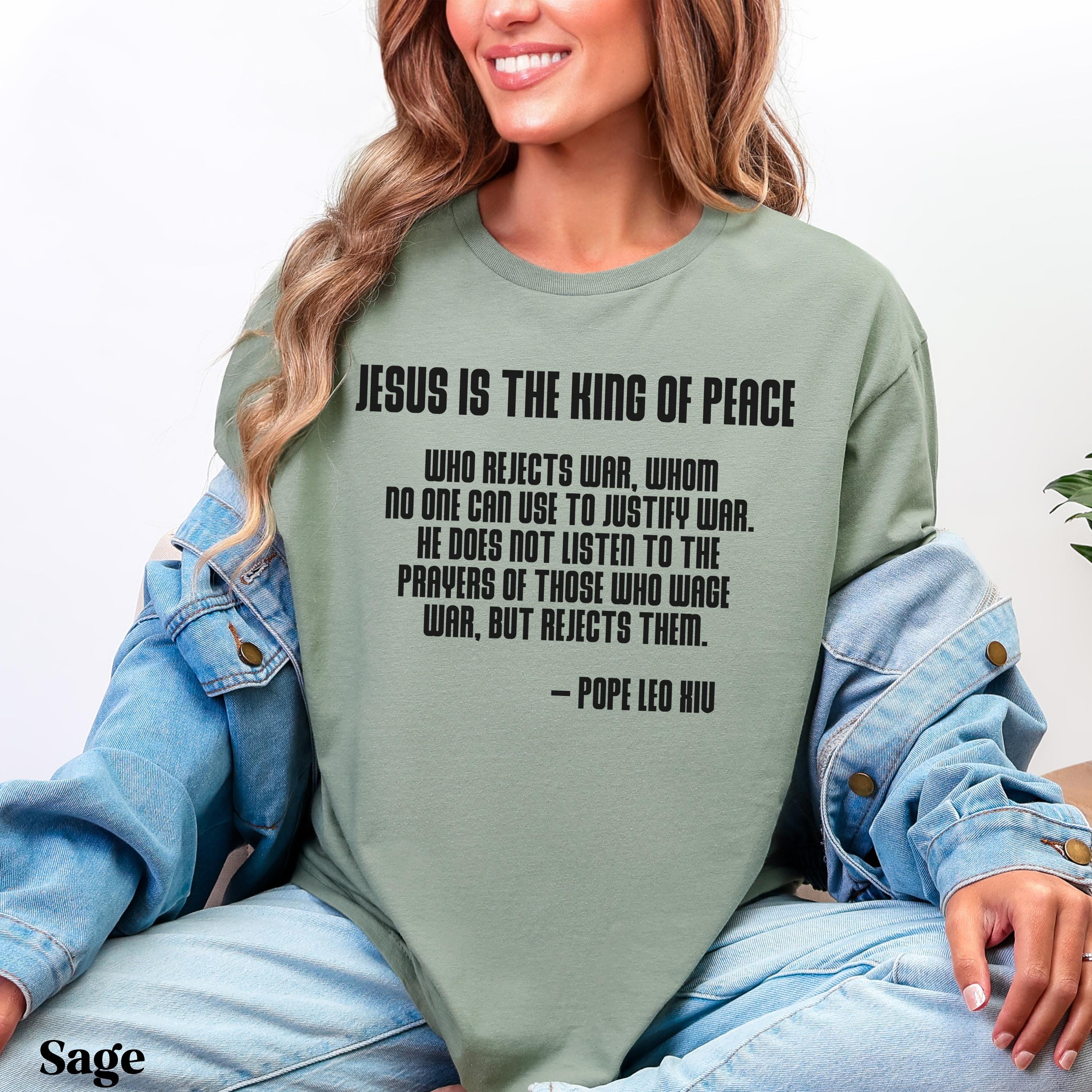 Sage green t-shirt with quote by Pope Leo X about Jesus being the king of peace.
