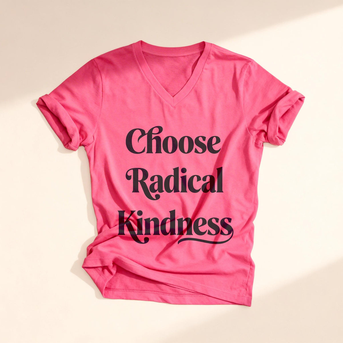 Pink t-shirt with "Choose Radical Kindness" text, laid flat.