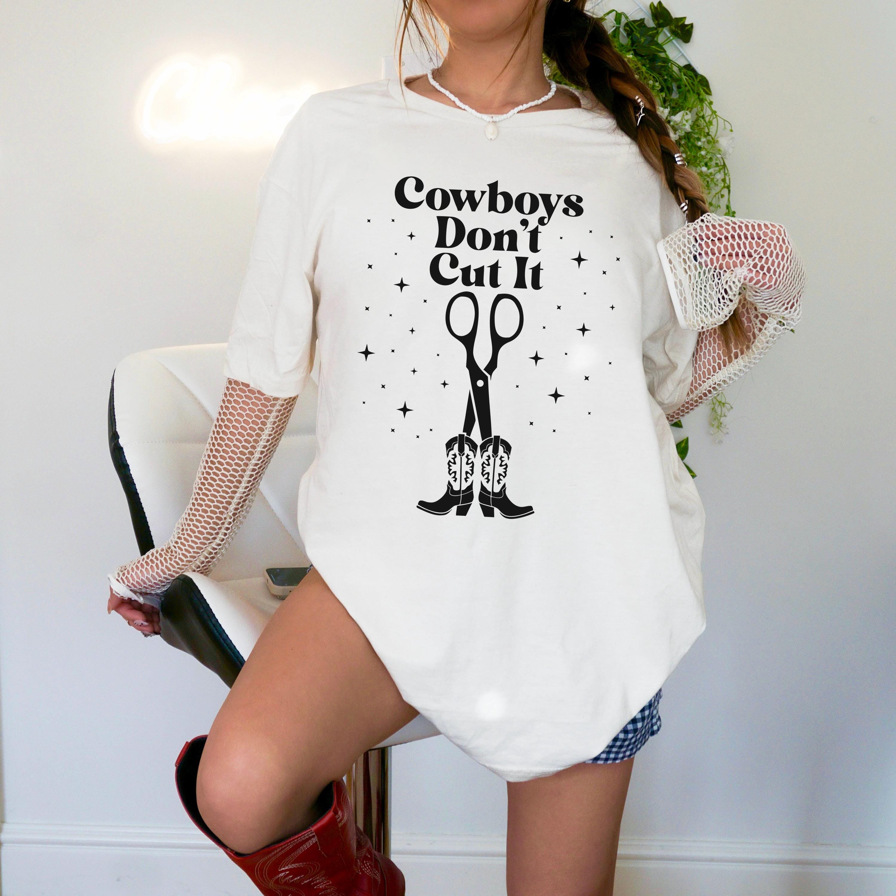 White t-shirt with scissors and cowboy boots graphic and text "Cowboys Don&