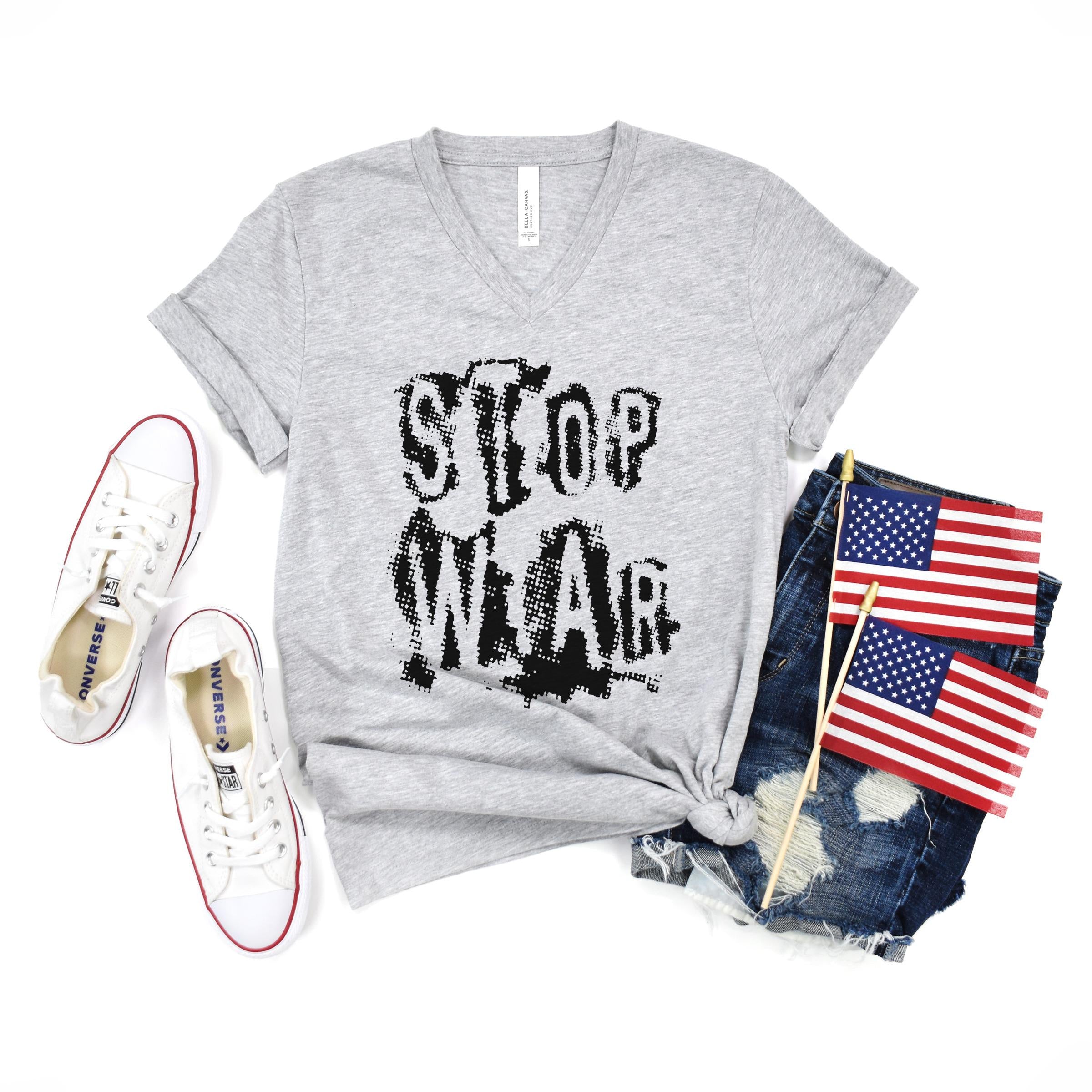 Grey t-shirt with "STOP WAR" text, denim shorts, and American flags.