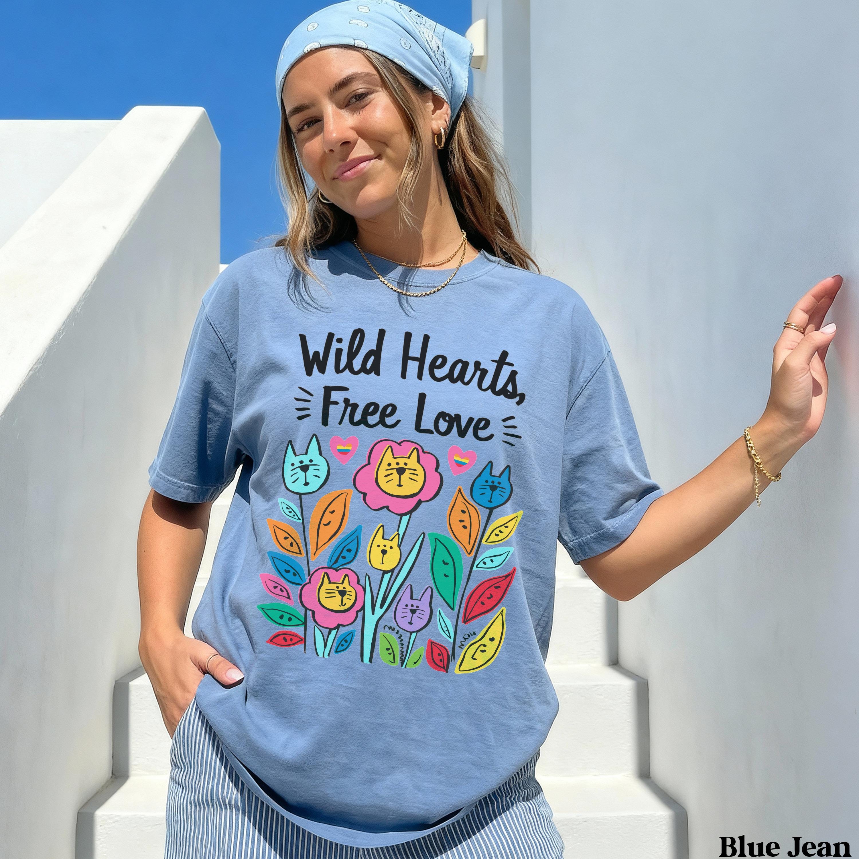 Blue t-shirt with "Wild Hearts, Free Love" text and colorful cat and flower design.