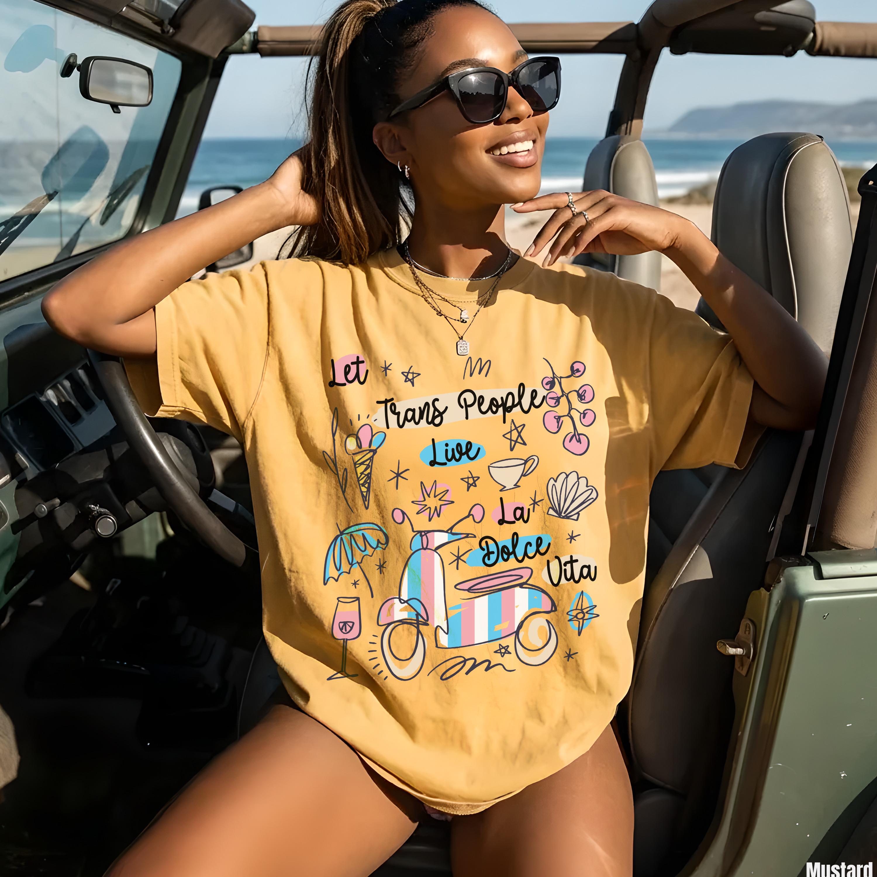 Yellow t-shirt with "Let Trans People Live La Dolce Vita" and beach graphics.