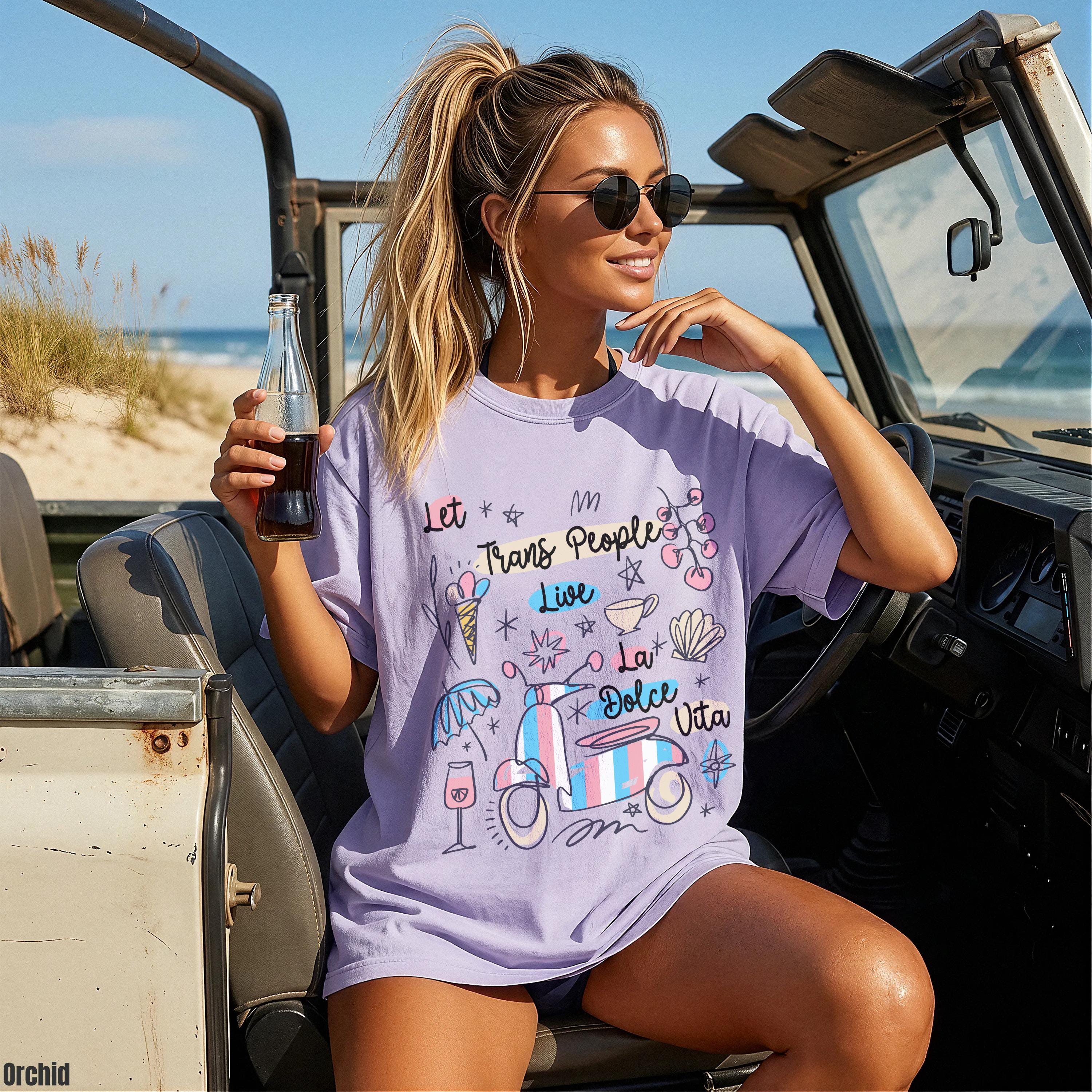 Lavender t-shirt with "Trans People Live Dolce Vita" graphic and playful illustrations.