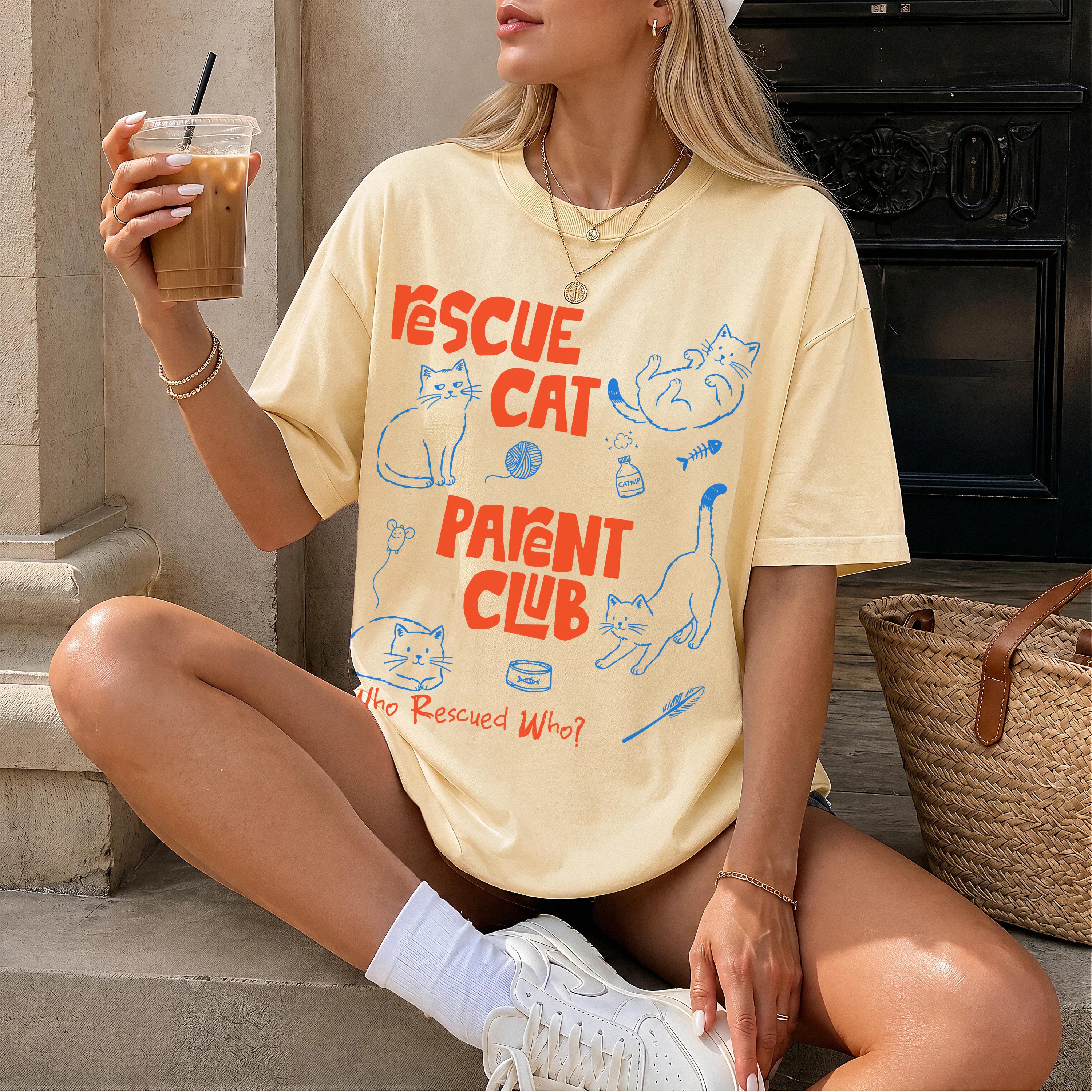 Yellow t-shirt with "Rescue Cat Parent Club" text and cat illustrations.