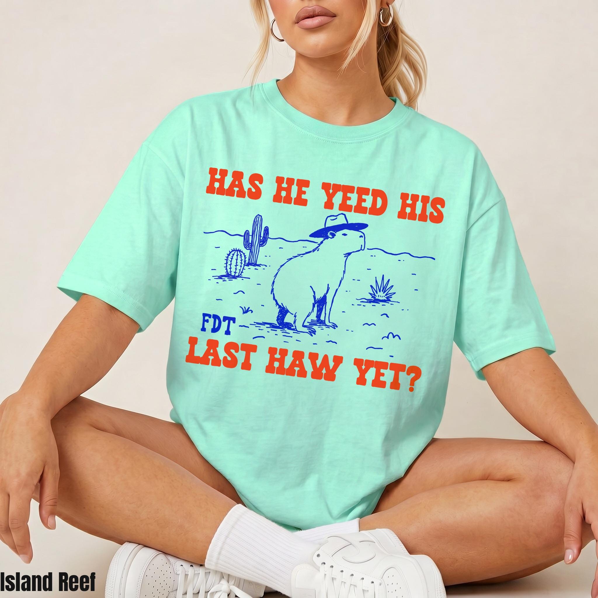 Mint t-shirt with graphic "HAS HE YEED HIS FDT LAST HAW YET?" and a capybara.
