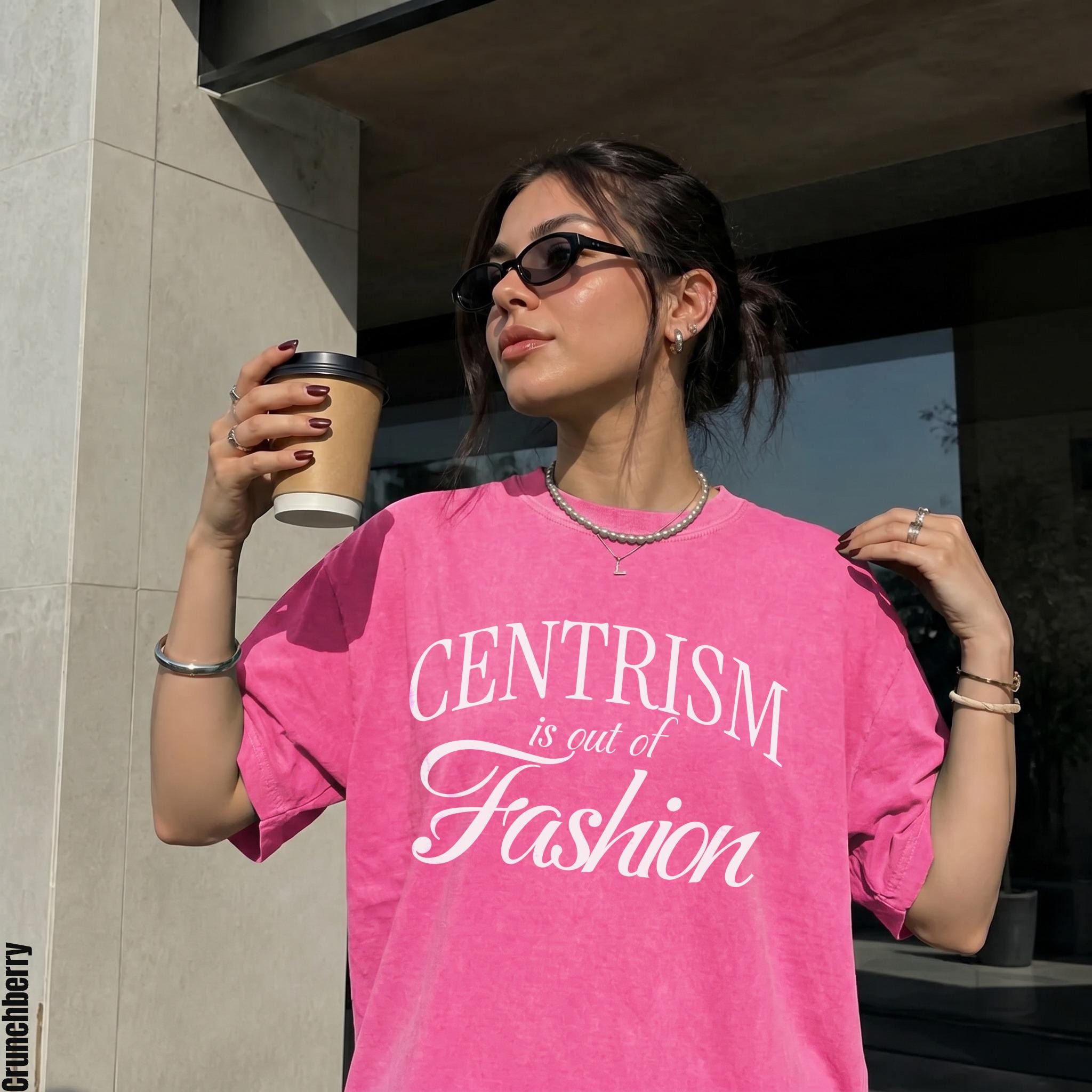 Pink t-shirt with white text "CENTRISM is out of Fashion" worn by a woman.