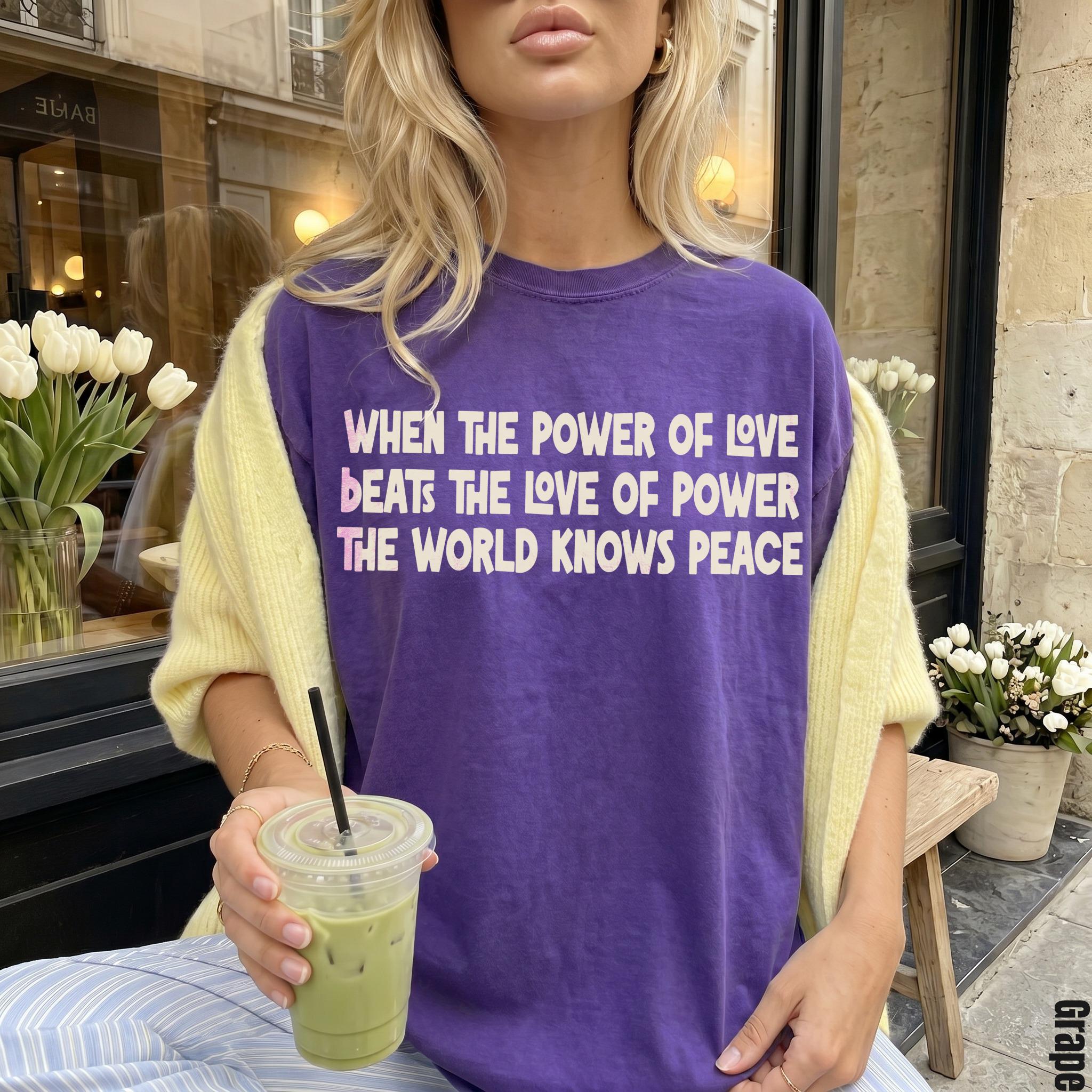 Purple t-shirt with text "When the power of love beats the love of power the world knows peace".