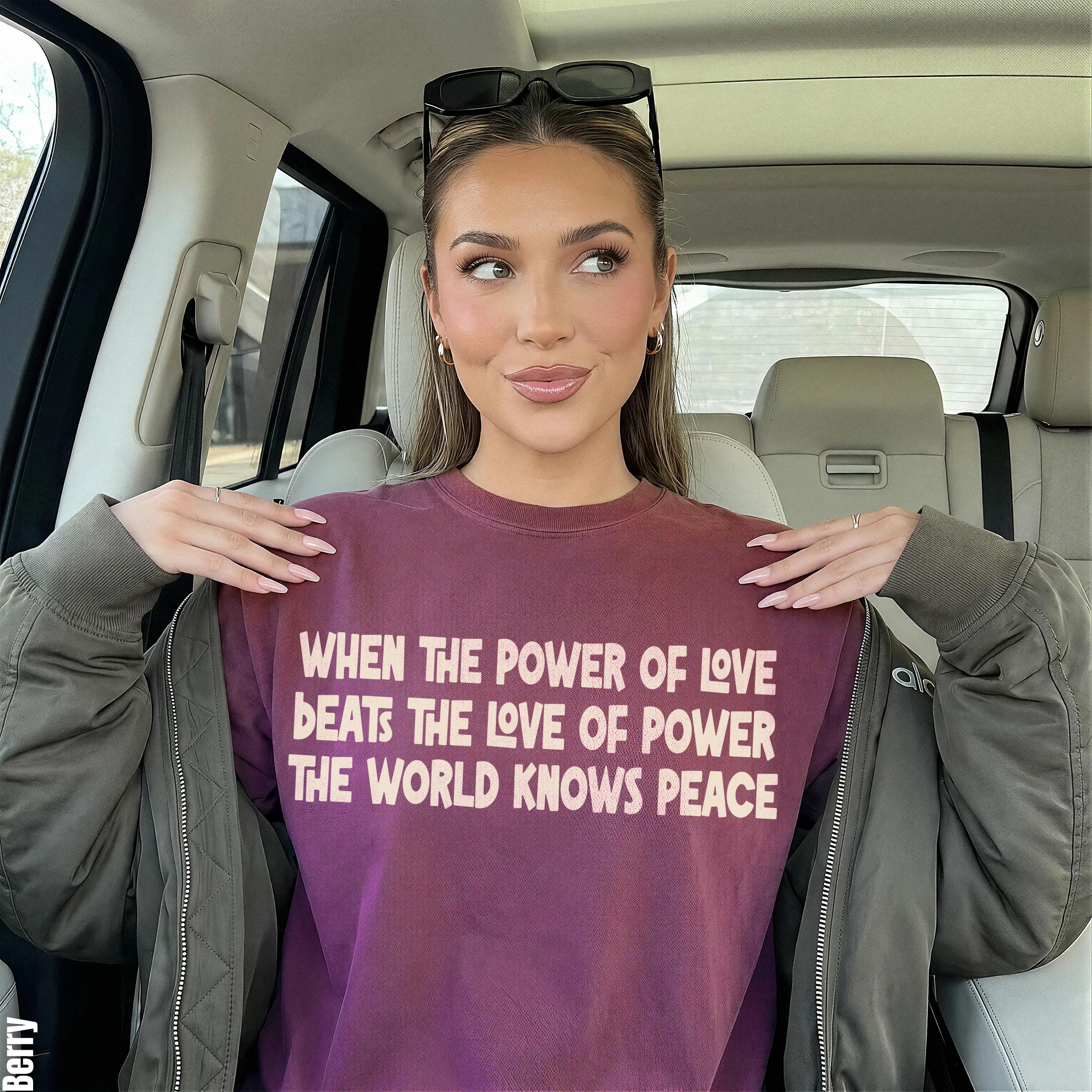 Woman wearing a maroon sweatshirt with white text, sitting in a car.