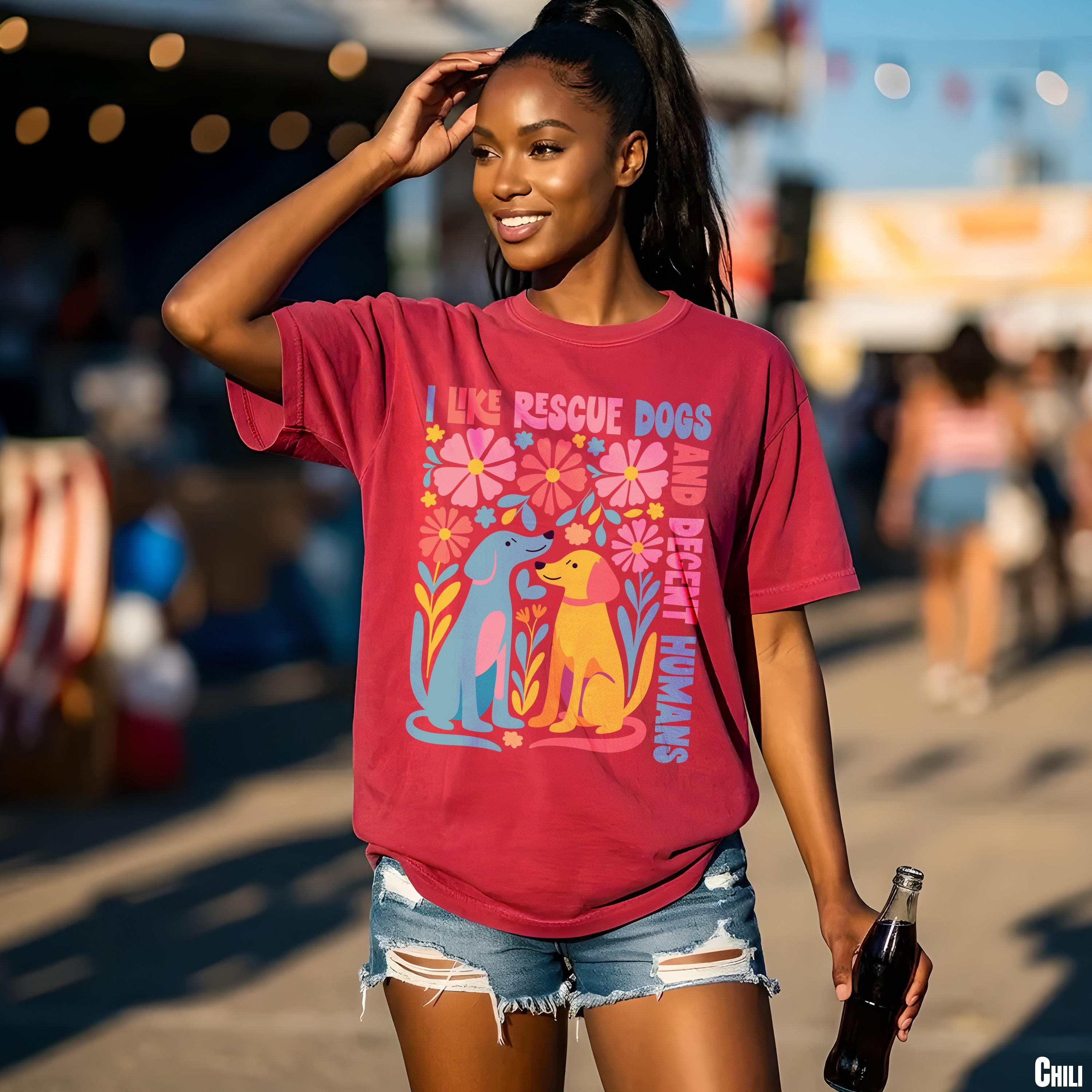Woman in maroon t-shirt with colorful dog and flower graphic.