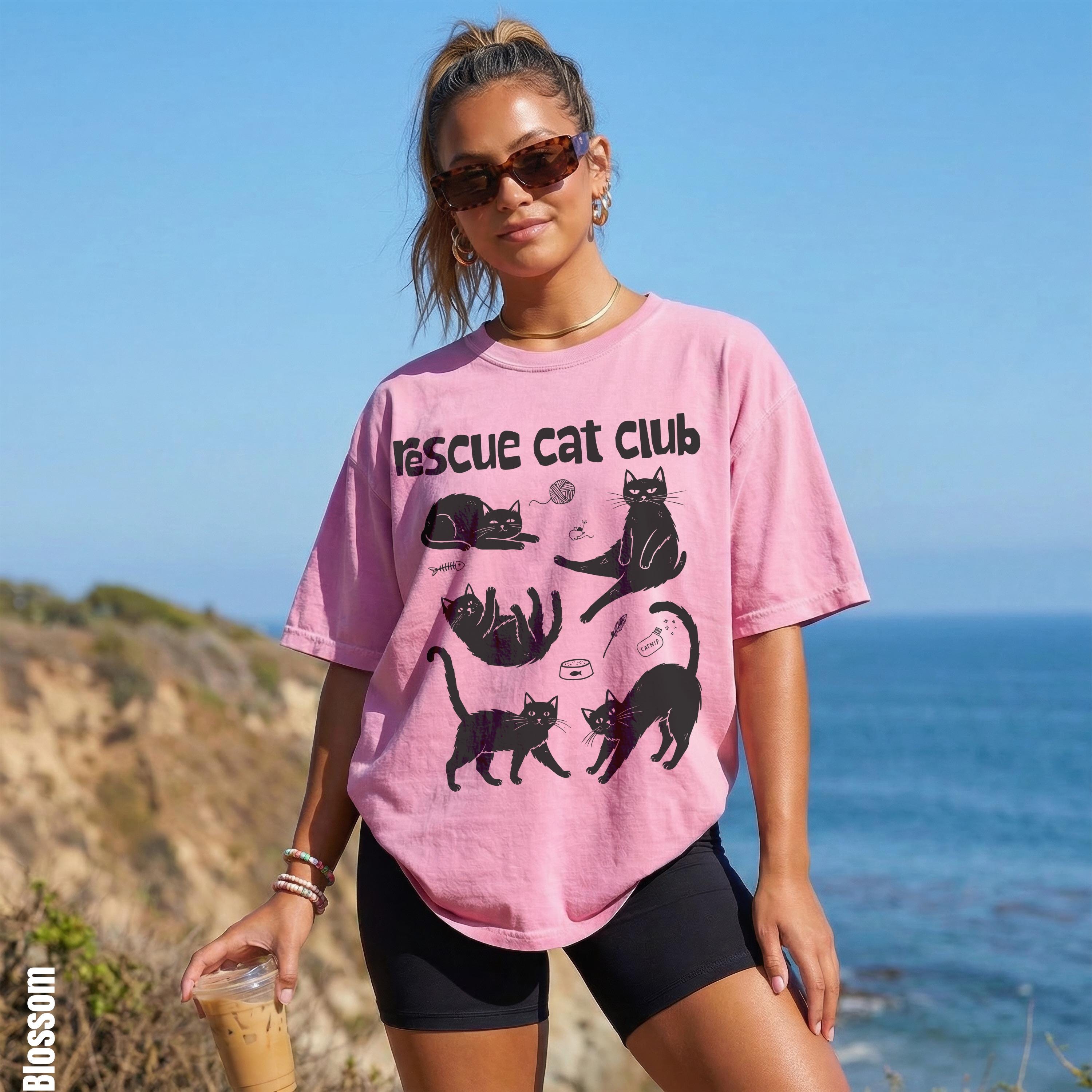 Pink t-shirt with black cat graphics and "Rescue Cat Club" text.