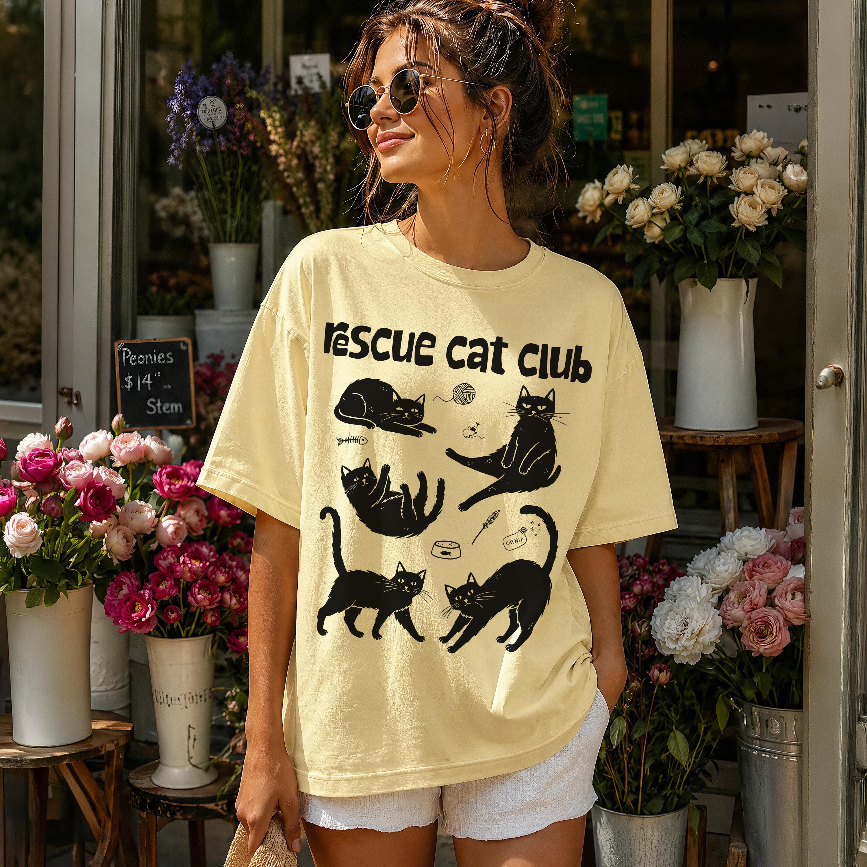 Yellow t-shirt with black cat illustrations and "Rescue cat club" text.