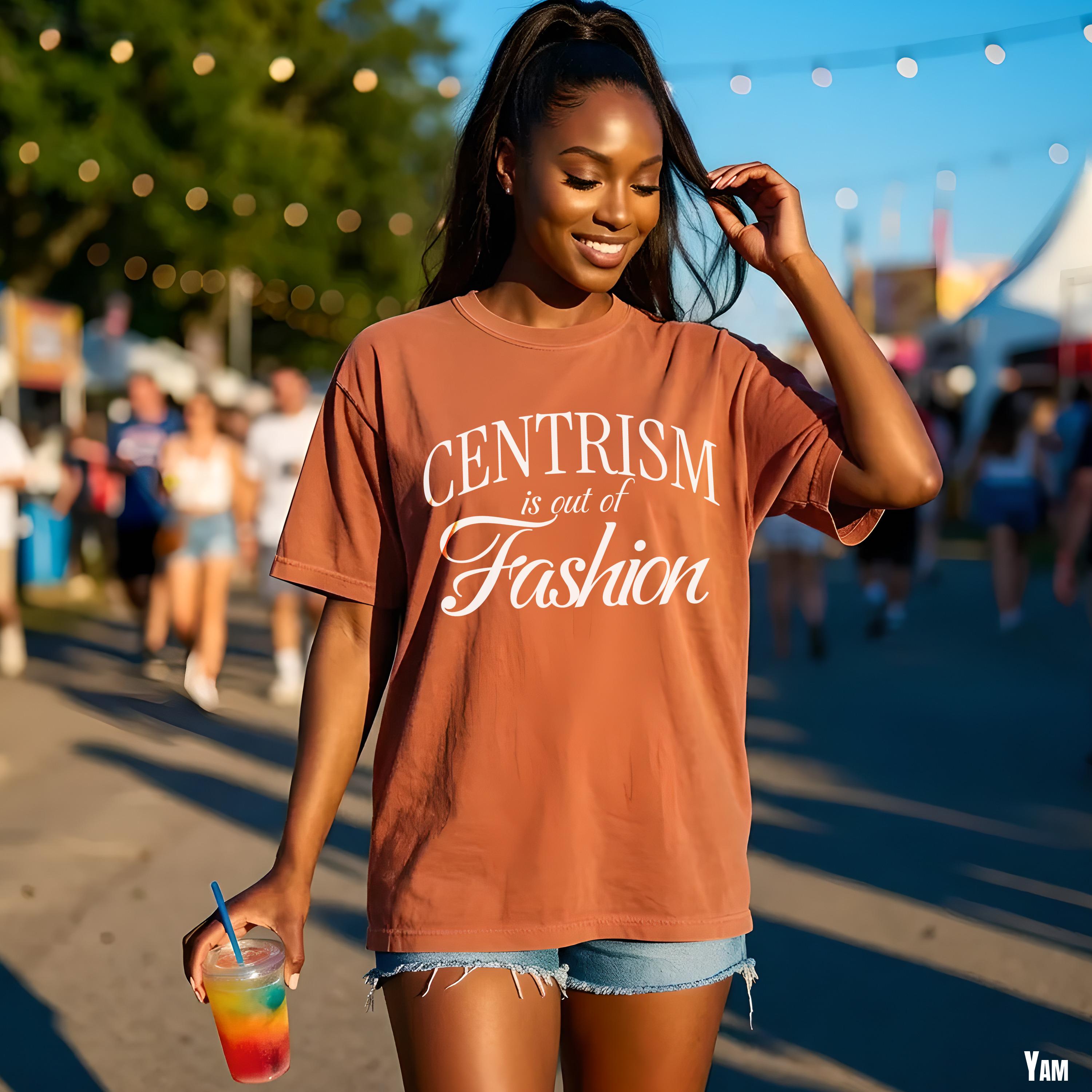 Woman in brown t-shirt with "Centrism is out of Fashion" text, holding colorful drink.