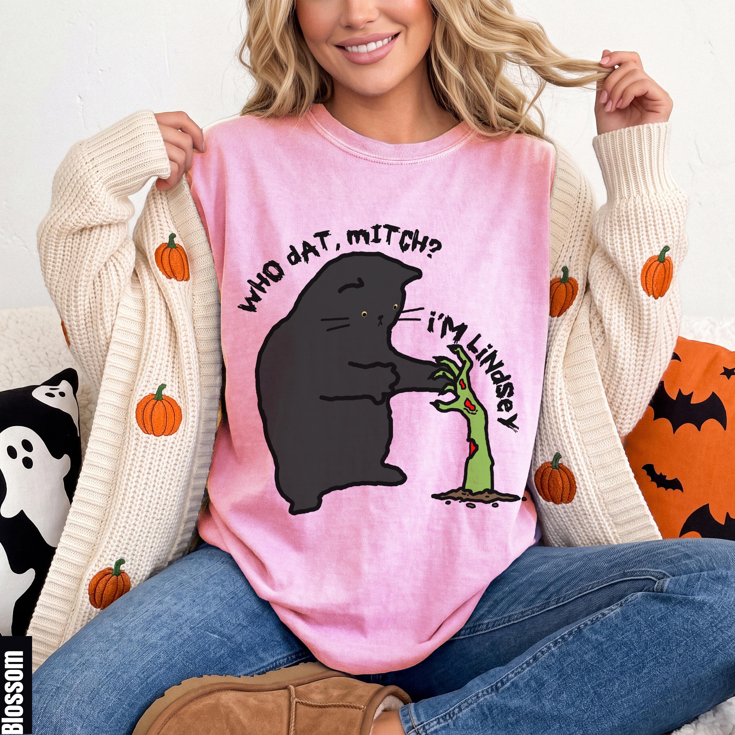 Pink t-shirt with black cat graphic saying "WHO DAT, MITCH? I&