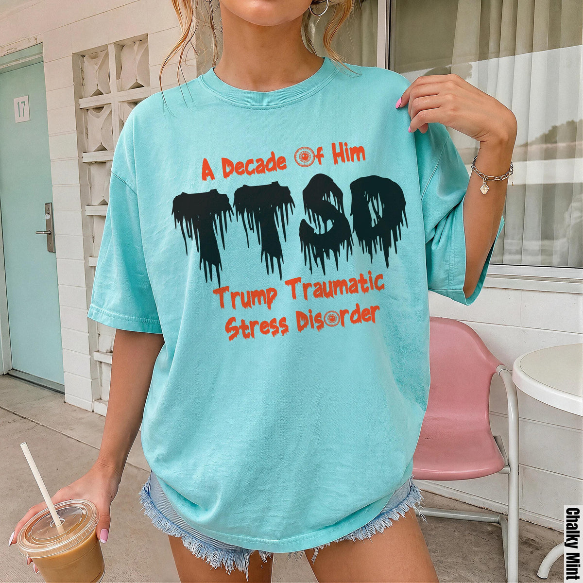 Aqua t-shirt with distressed black TTSD graphic and orange text "A Decade of Him" and "Trump Traumatic Stress Disorder".