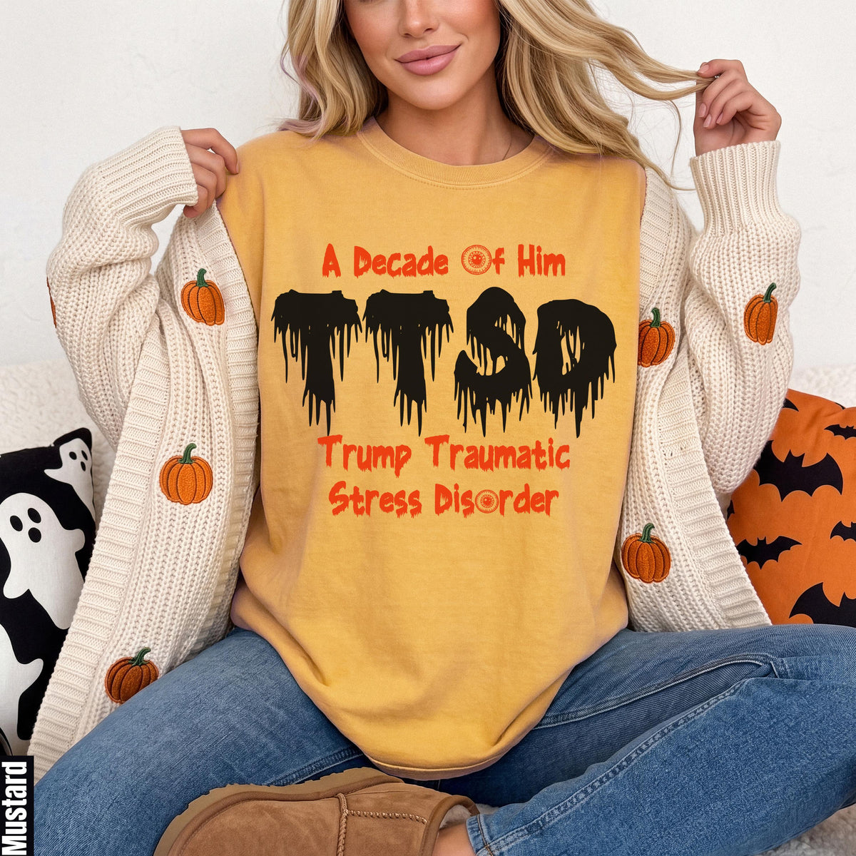 Woman wearing yellow t-shirt with "TTSD Trump Traumatic Stress Disorder" in melting black and orange text.