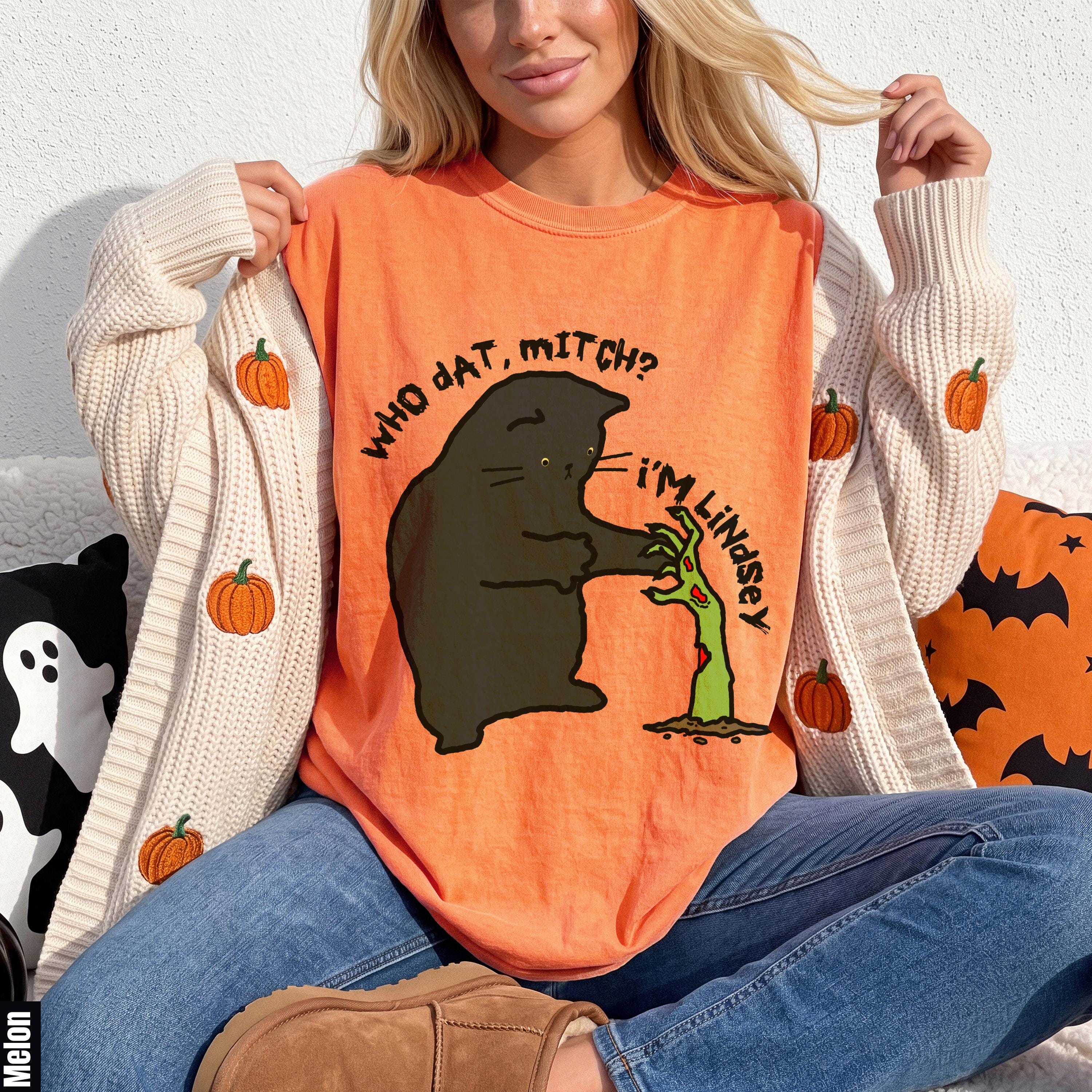 Orange t-shirt with black cat and zombie hand graphic, "Who dat, Mitch? I&