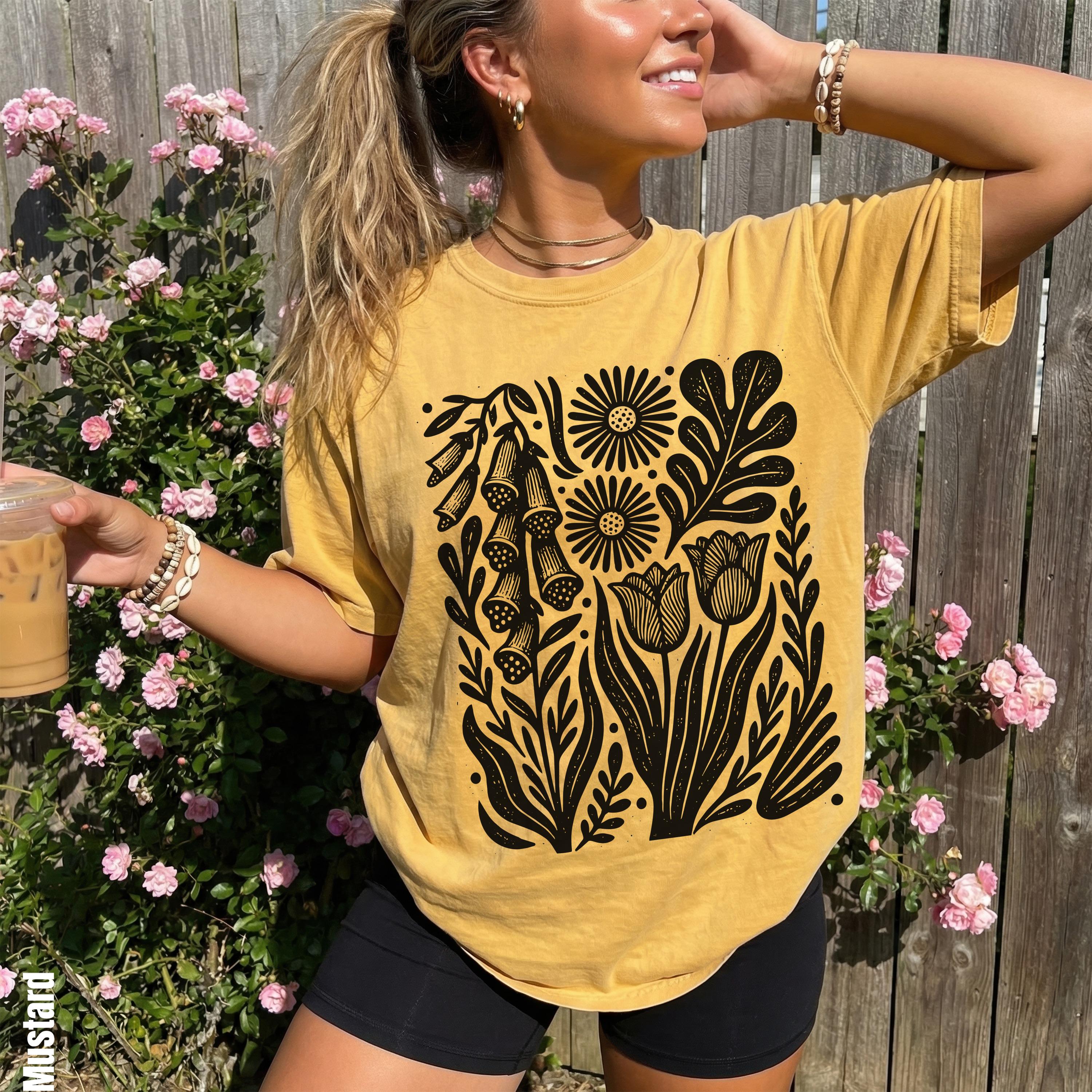 Mustard t-shirt with black floral design featuring tulips and bellflowers.