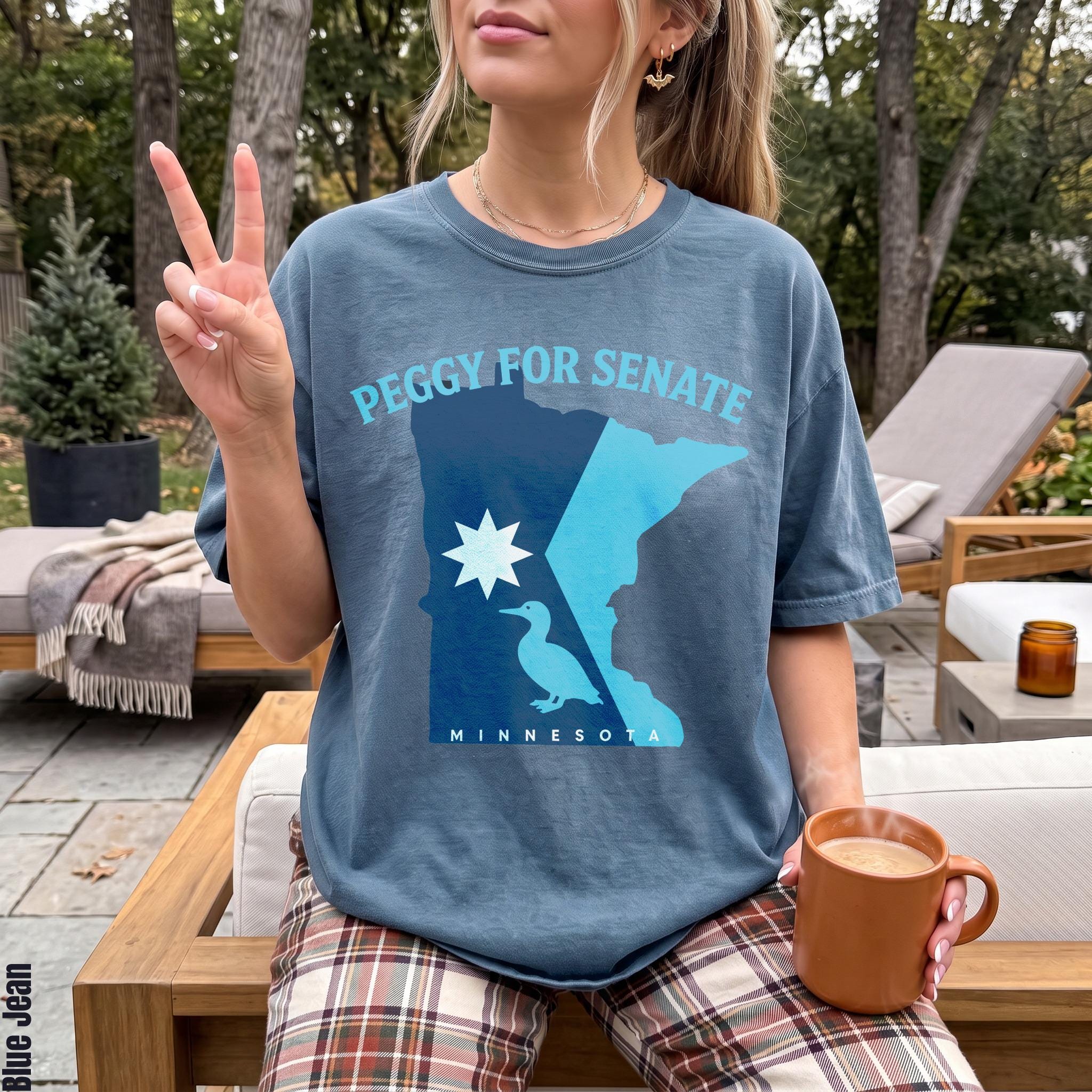 Blue t-shirt with "Peggy for Senate Minnesota" graphic featuring state outline, star, and duck.