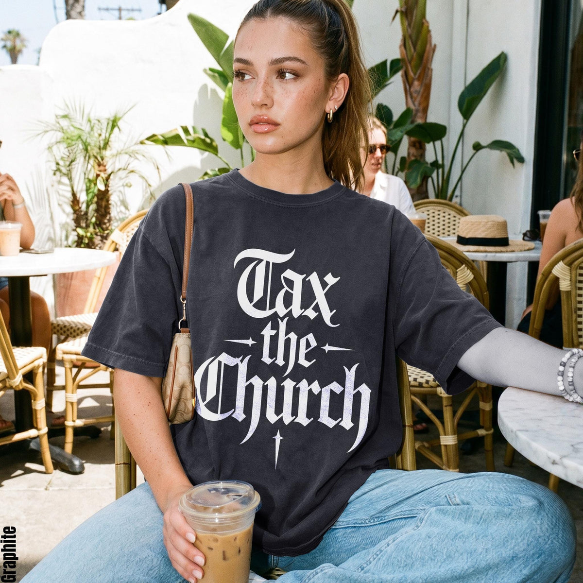 Dark grey t-shirt with "Tax the Church" text and a cross graphic.