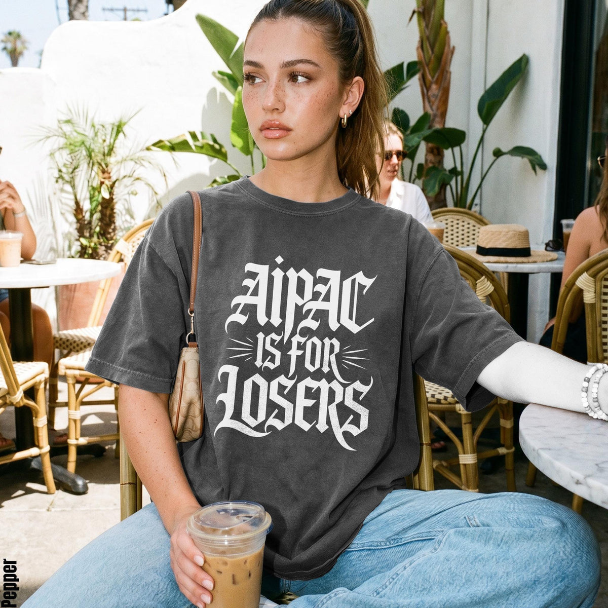 Woman wearing a dark gray t-shirt with "Aipac Is For Losers" graphic.