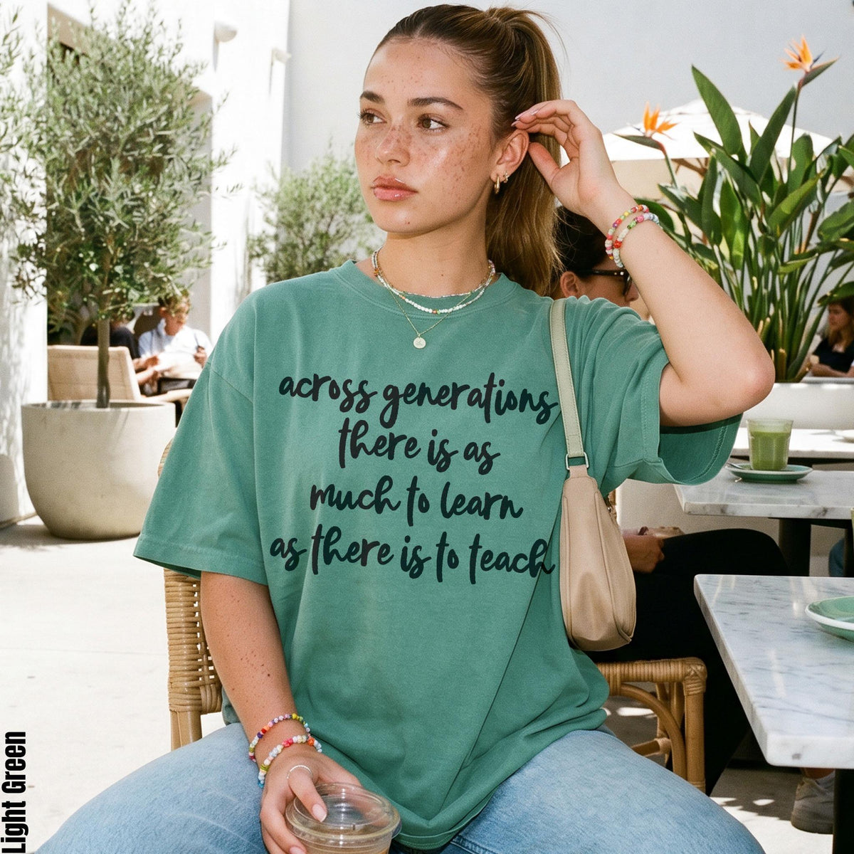 Green t-shirt with text "across generations there is as much to learn as there is to teach".