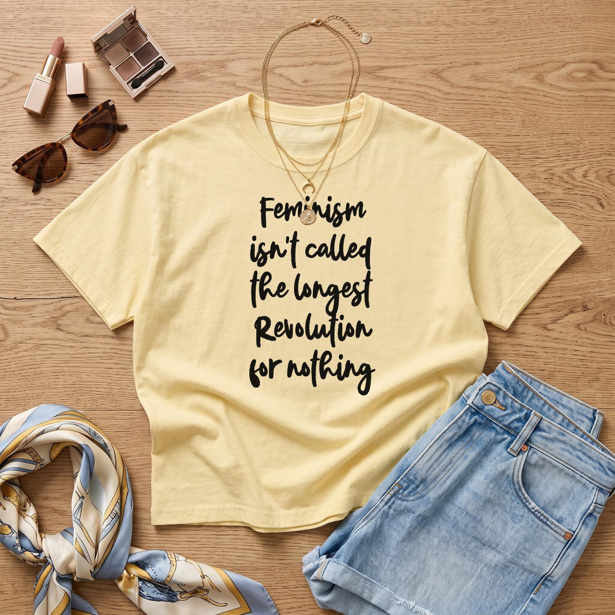 Pale yellow t-shirt with black text reading "Feminism isn&