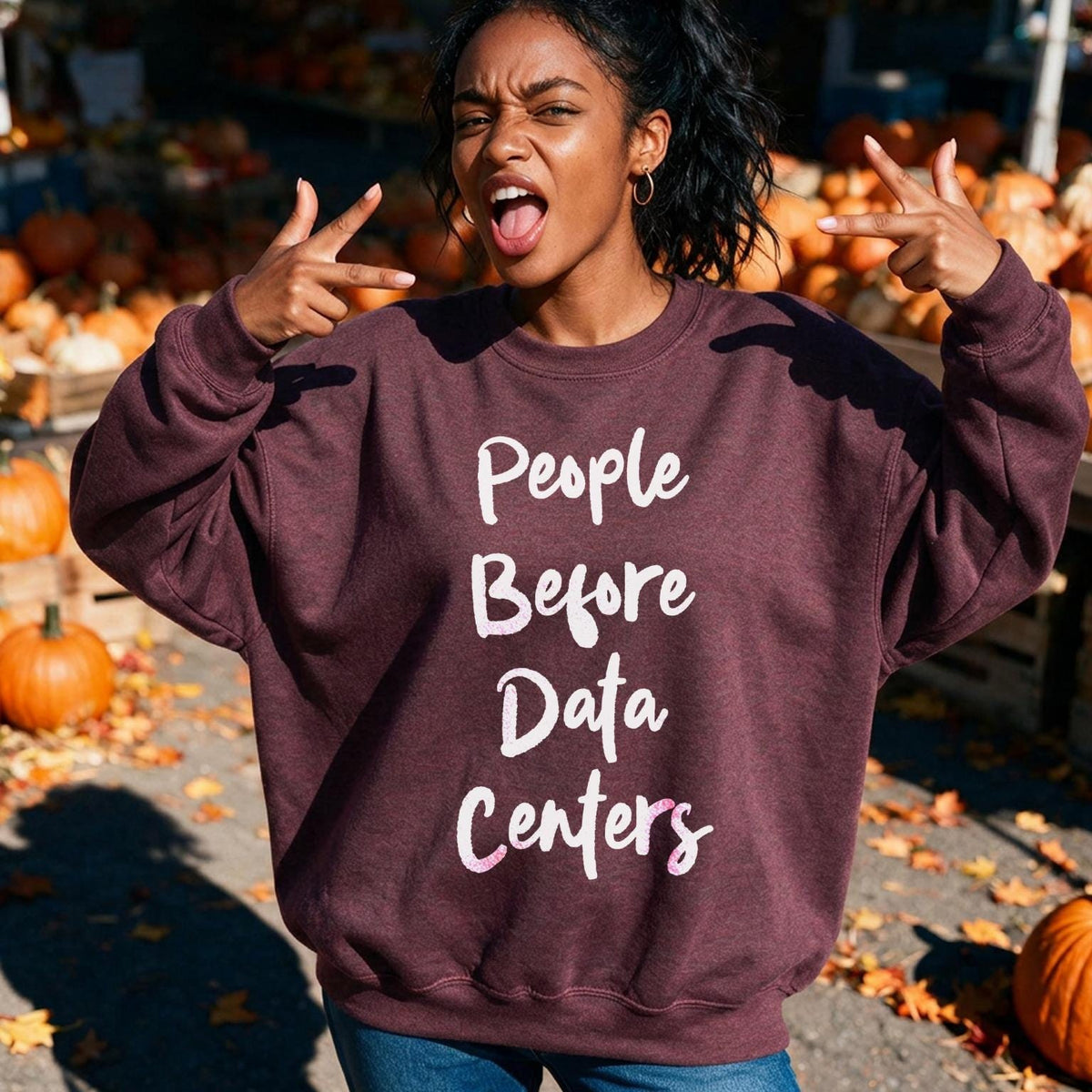 Burgundy sweatshirt with "People Before Data Centers" text, worn by woman in pumpkin patch.
