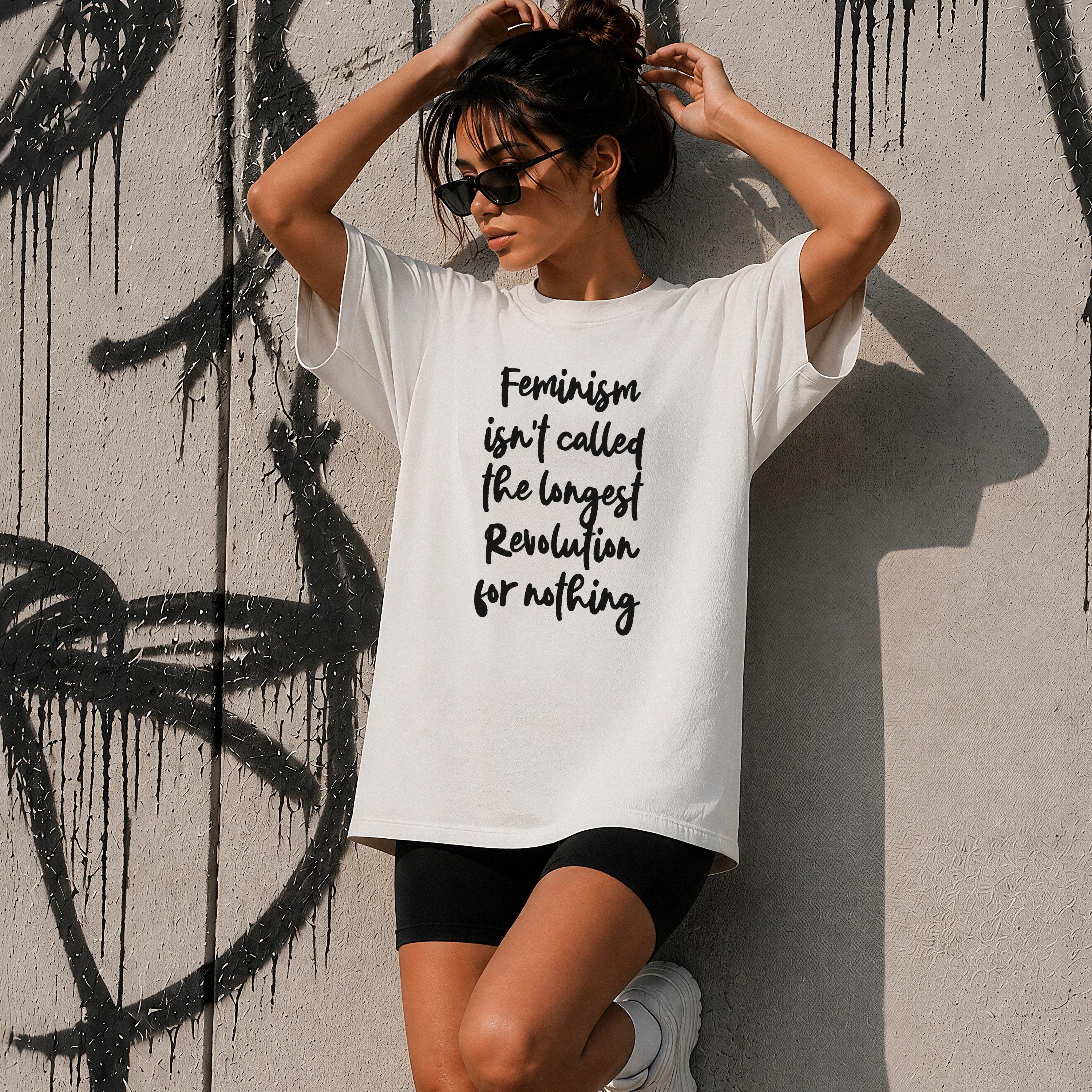 White t-shirt with black text reading "Feminism isn&