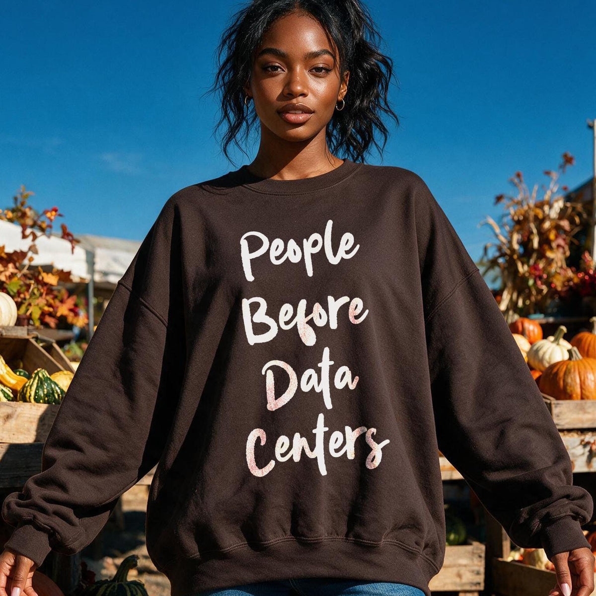 Brown sweatshirt with white text "People Before Data Centers" on a woman.