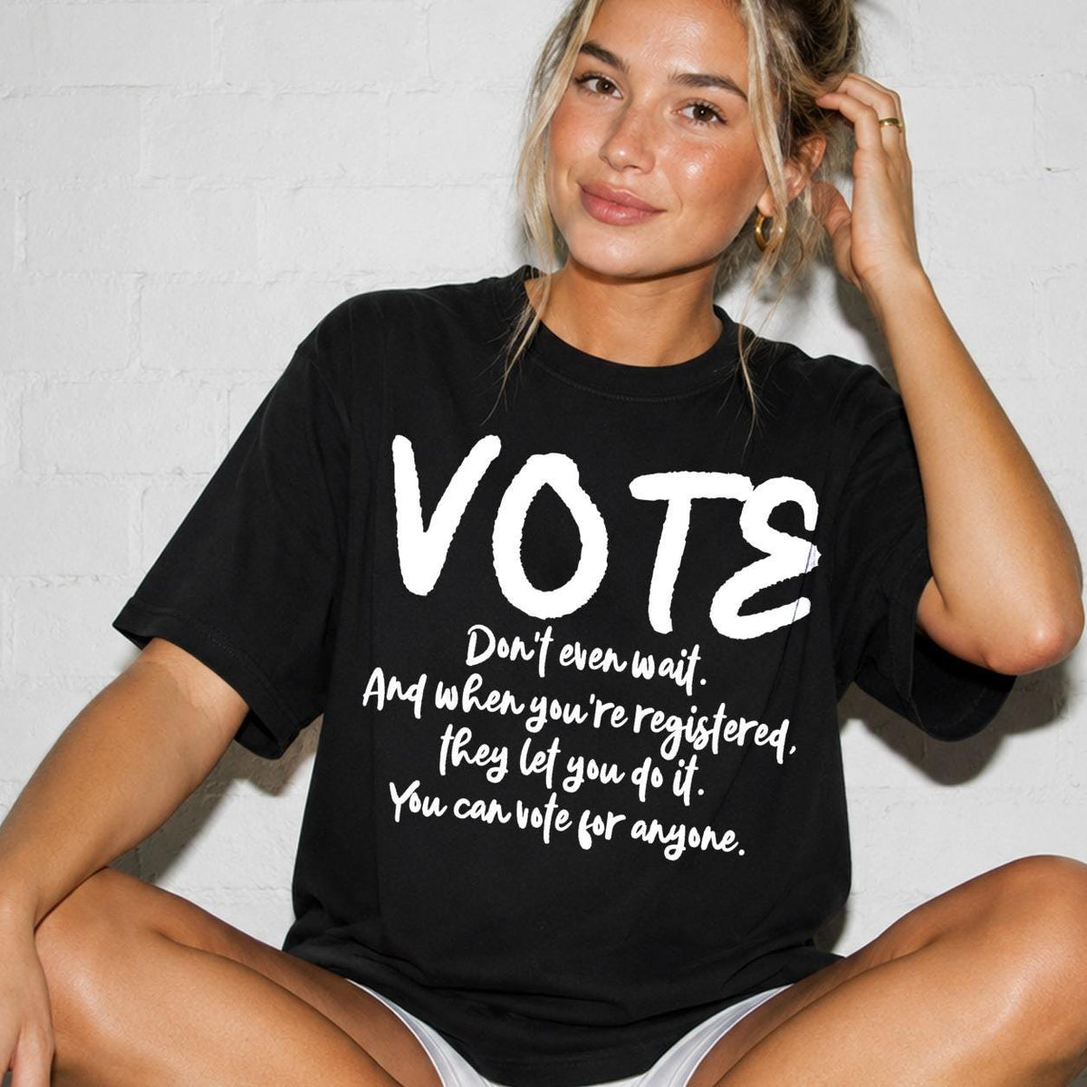 Black t-shirt with "VOTE" and registration message.