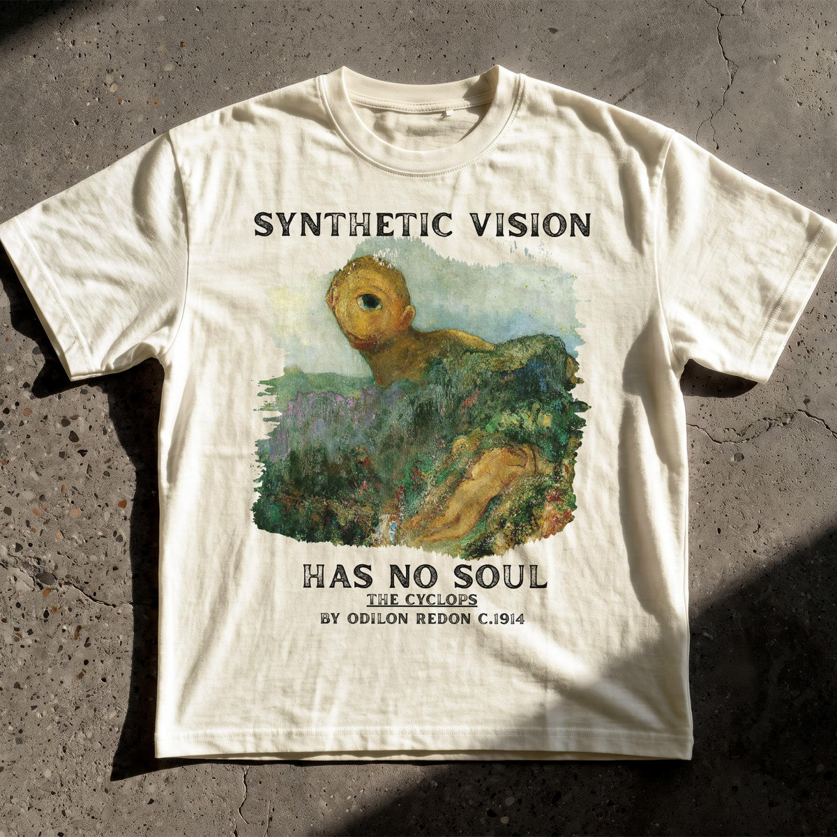 Cream t-shirt with "Synthetic Vision Has No Soul The Cyclops" text and painting.