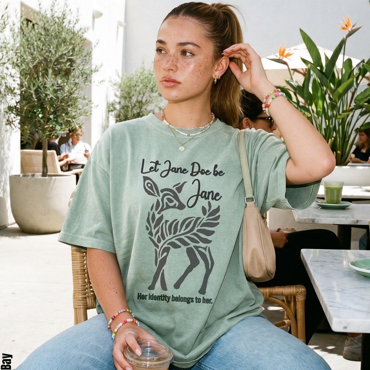 Green t-shirt with deer graphic and text "Let Jane Doe be Jane. Her identity belongs to her."