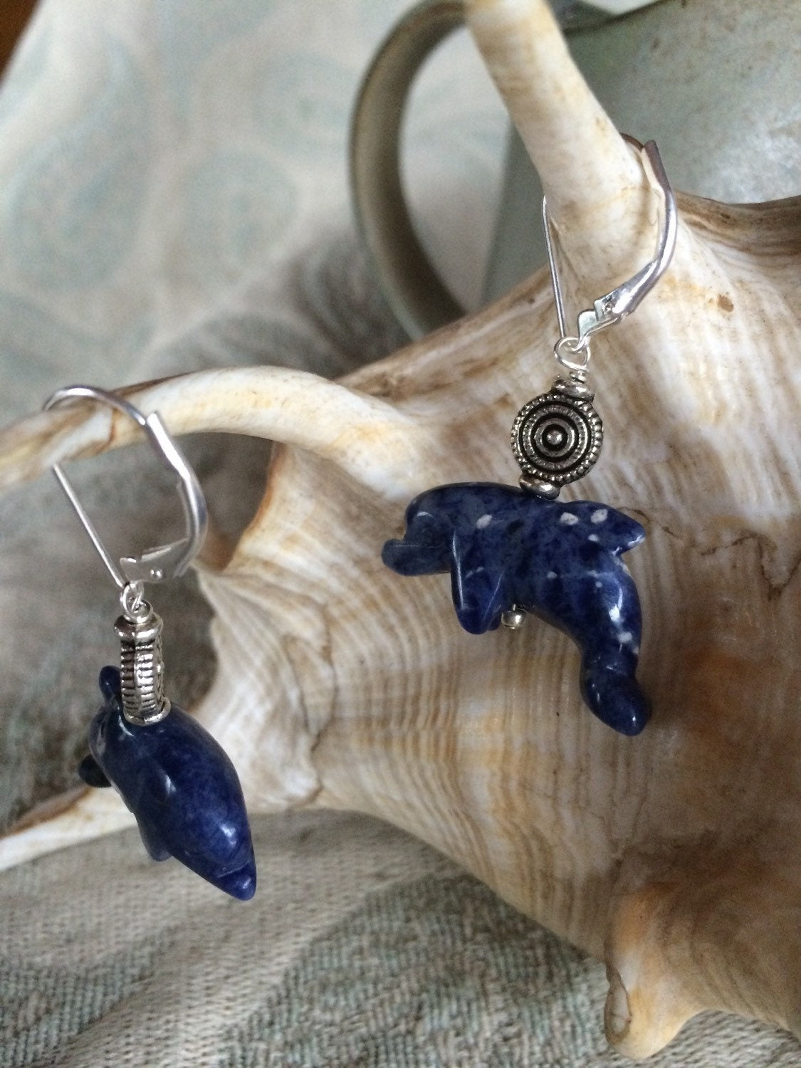 Dolphin Earrings in blue sodalite, showcasing a carved stone dolphin design perfect for ocean lovers, crafted from stunning sodalite with blue and white flecks.