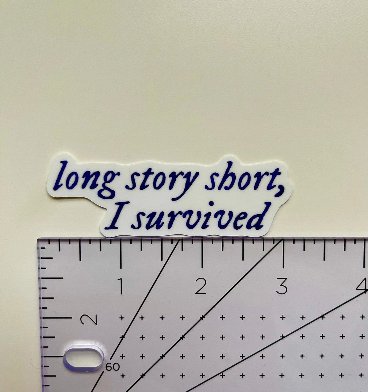 Long story short, I survived sticker flat lay — navy blue quote laptop sticker for journals and water bottles by indie artist MangoIllustrated