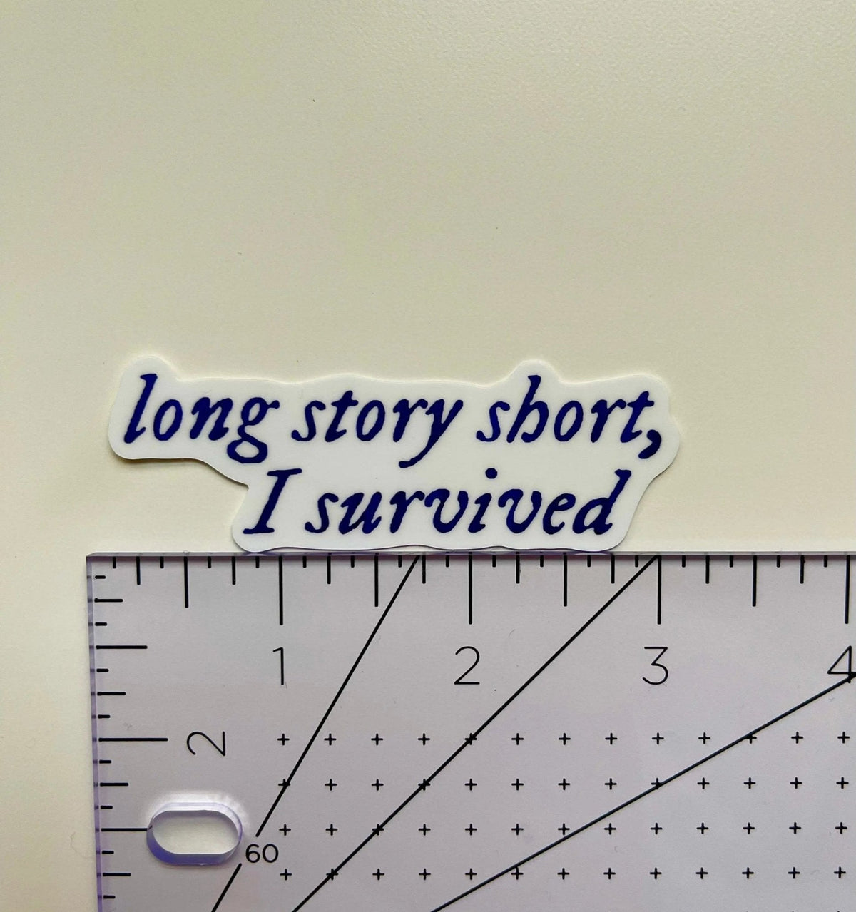 Long story short, I survived sticker flat lay — navy blue quote laptop sticker for journals and water bottles by indie artist MangoIllustrated