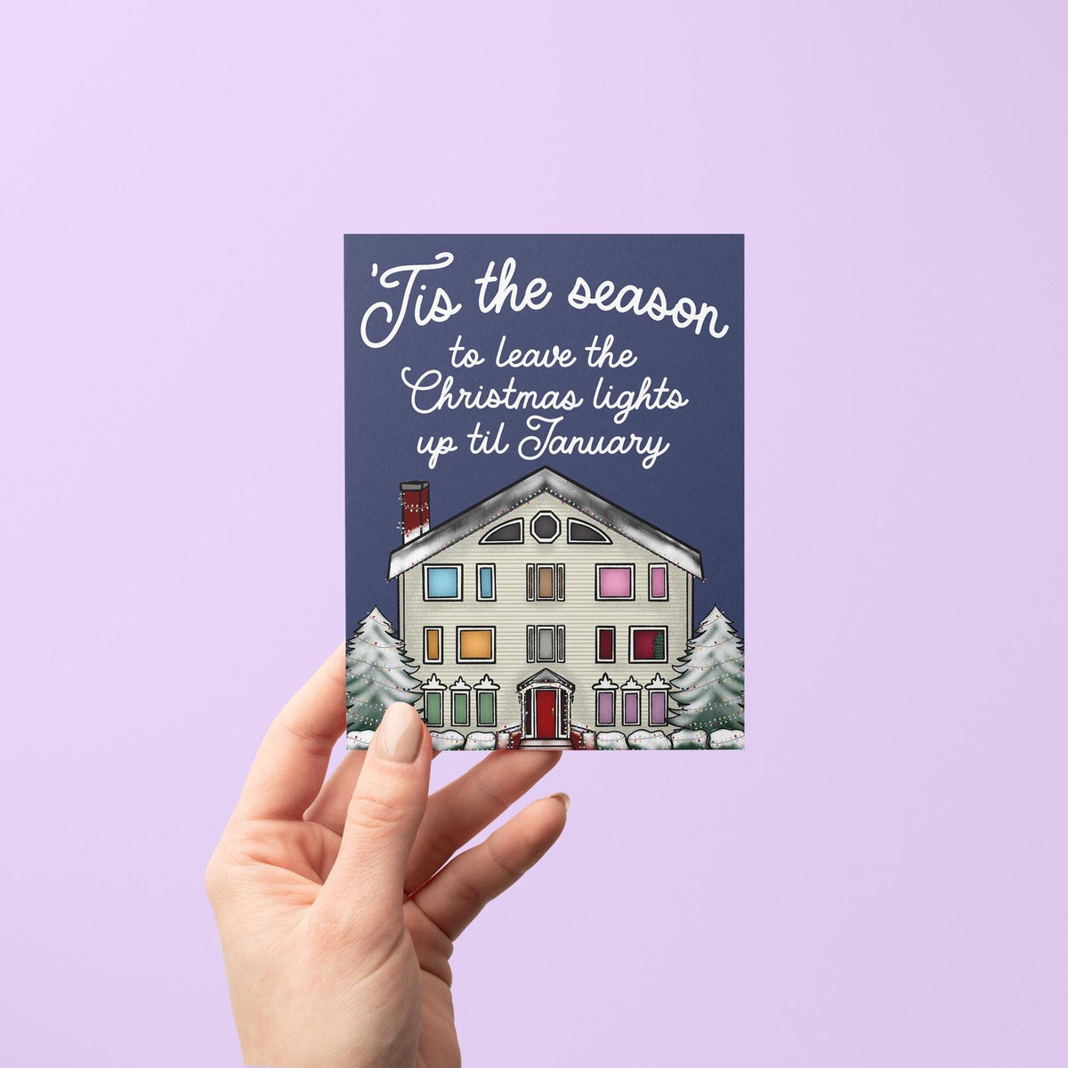Lover House Christmas card flat lay — illustrated holiday house card styled with holiday greenery, by indie artist MangoIllustrated
