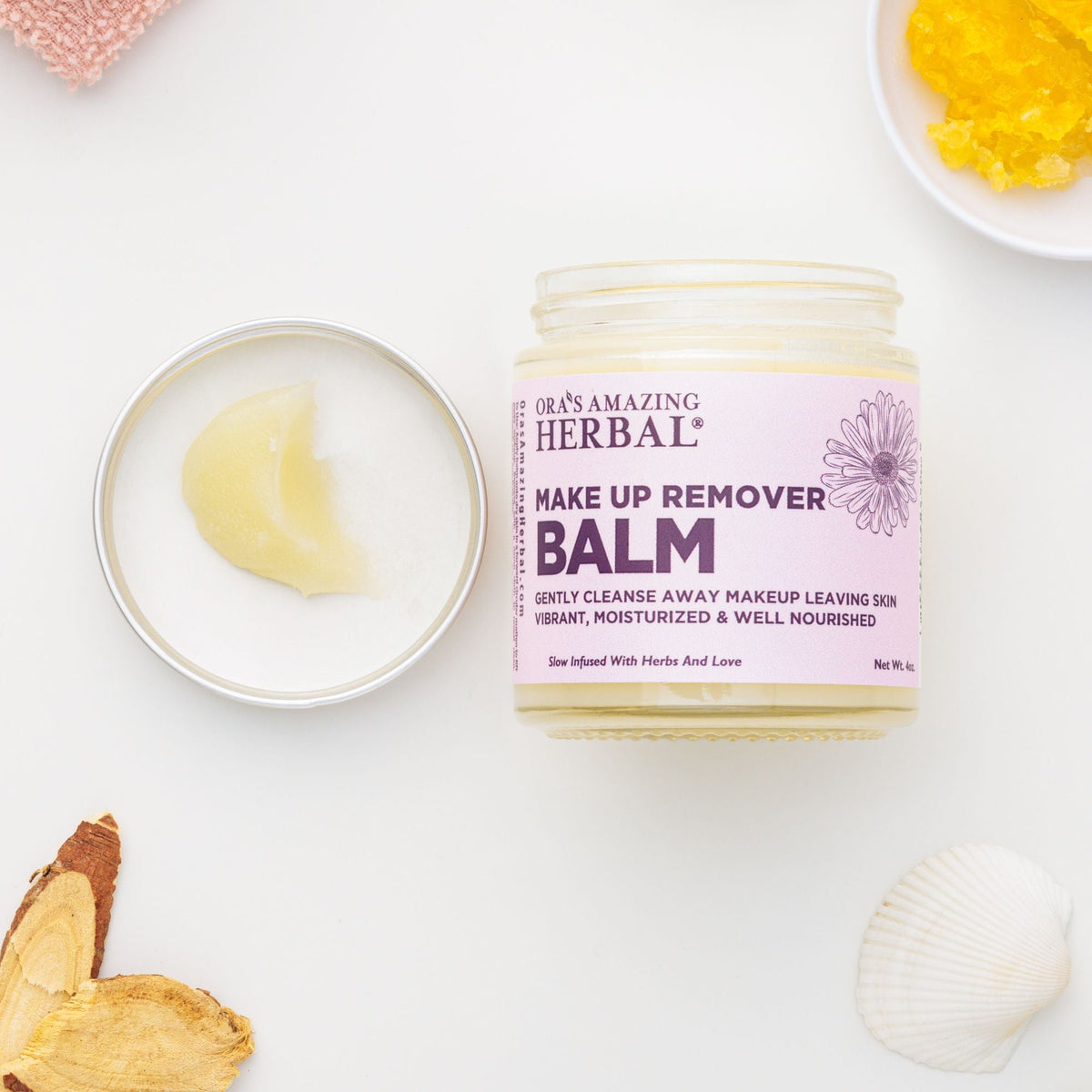 Makeup Remover Balm 4oz Lifestyle Indoor White Background Open Lid Texture Herbs Square