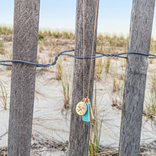 mantoloking charm necklace with semi-precious turquoise pendant freshwater stick pearl and seastar charm hanging on beach fencing
