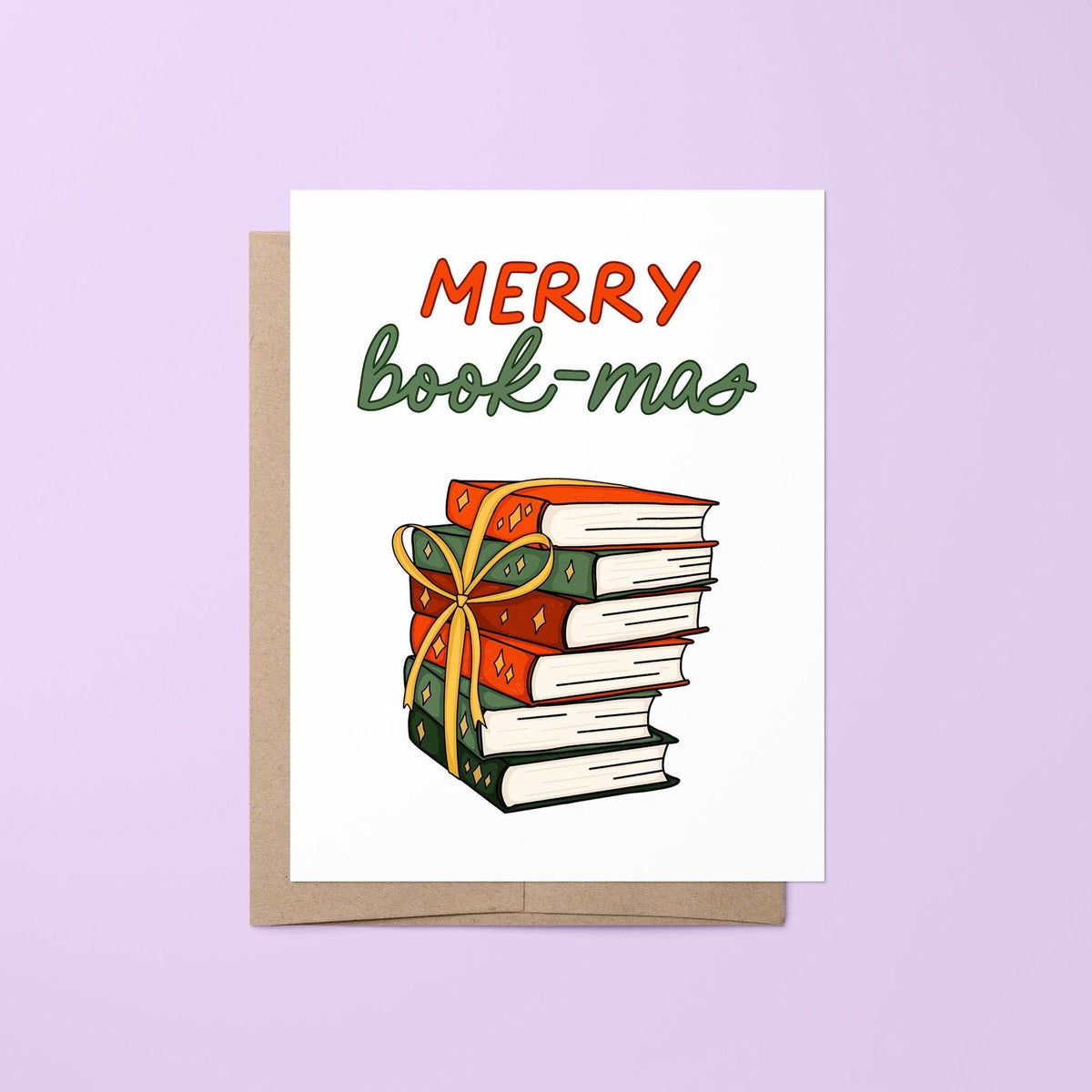 Merry Book-mas card — hand lettered Merry Book-mas greeting in red and green over an illustrated stack of festive books with a gold ribbon bow, 4.25 x 5.5 in folded, by MangoIllustrated